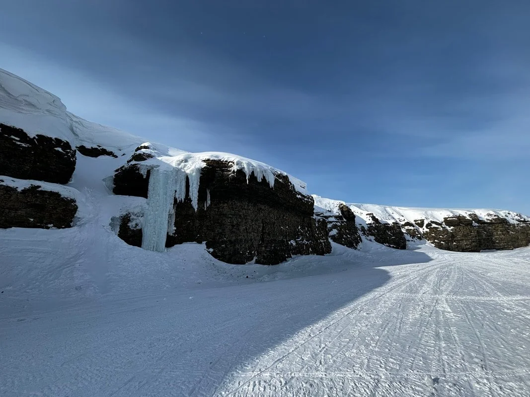 Paesaggio invernale con scogli coperti di neve e ghiaccio, sotto un cielo blu, Isole Svalbard.