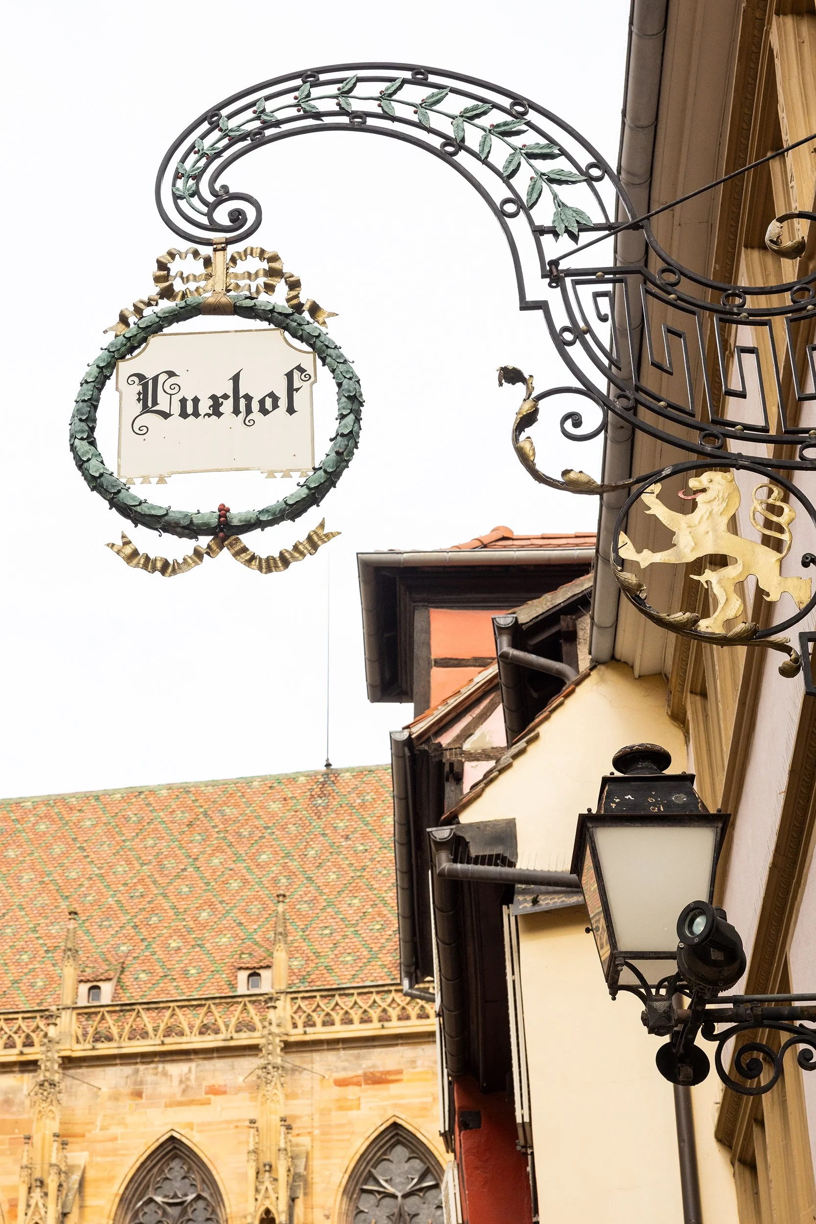Merchant guild sign on Rue Mercière with view of Collégiale Saint-Martin, Colmar