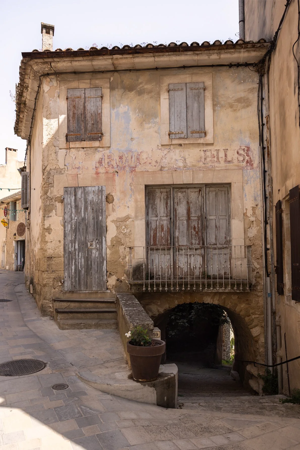 Building-with-faded-sign-Rue-Raoul-St-Raymond-Sylvestre-Menerbes-Luberon-France.jpg