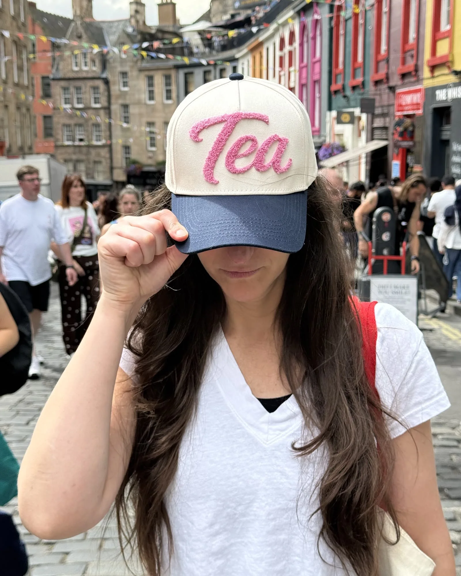 Comedian Jennifer Jane wearing the Tea Hat on a busy Edinburgh street
