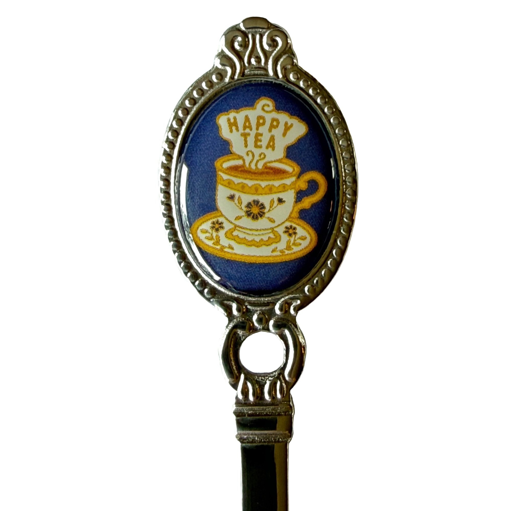 Close-up of the royal blue Happy Tea teaspoon crest, engraved with a teacup