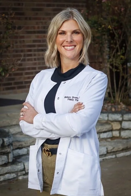 Portrait of Mallory Brown, AGNP-C, family practice nurse practitioner standing outside The Clinic at Glen Rose.