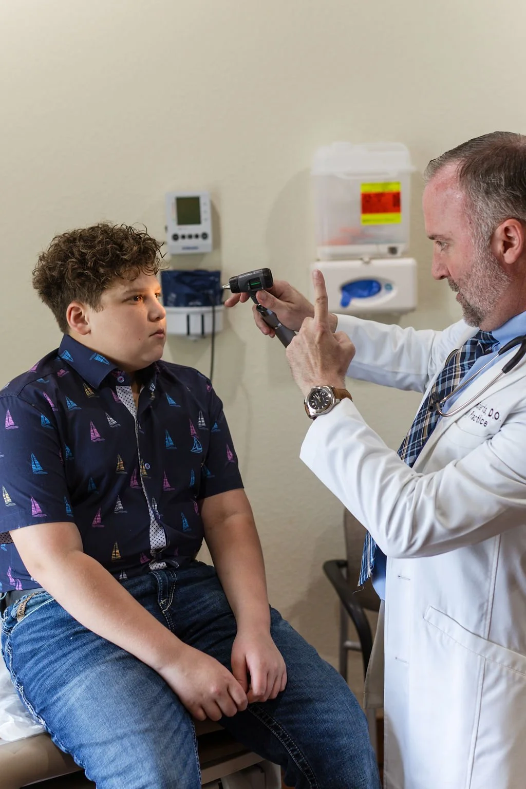 Family practice doctor providing pediatric primary care exam during a wellness visit at the Clinic at Glen Rose in Glen Rose, Texas.