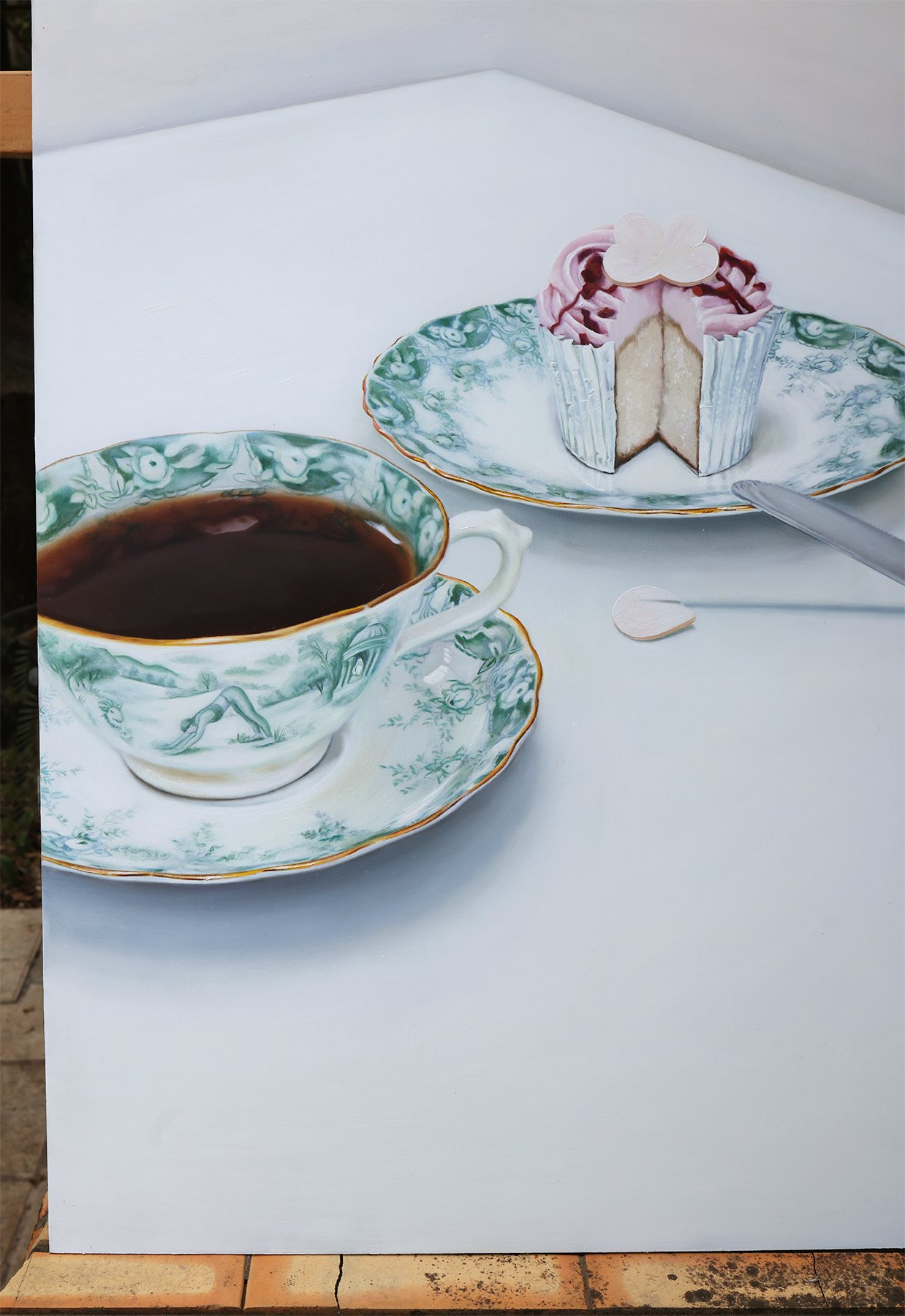 Knife Skills, oil painting by Tereza Barnard, cupcake sliced on a serving plate, teacup with a pastoral scene next to it