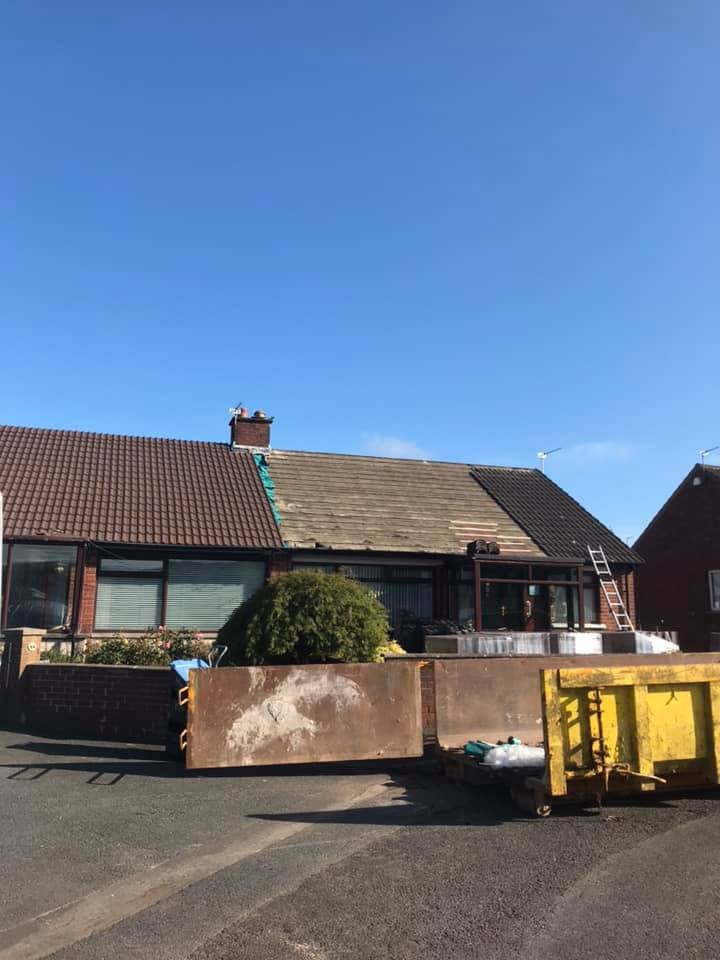 Before: bungalow with an old dark roof and a skip in the driveway