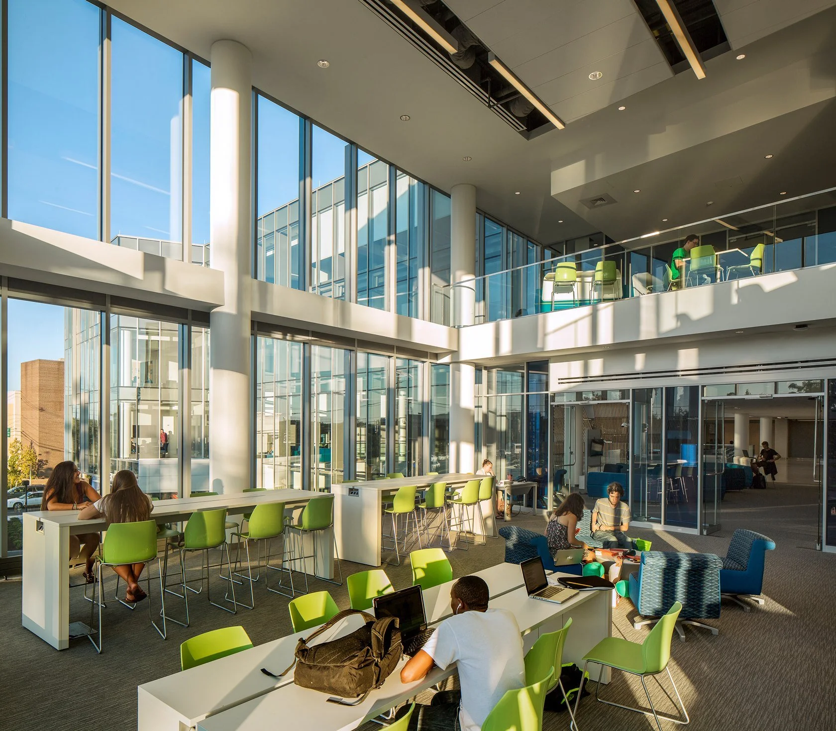 04-university-crossing-students-at-tables-in-a-double-height-space-with.jpg
