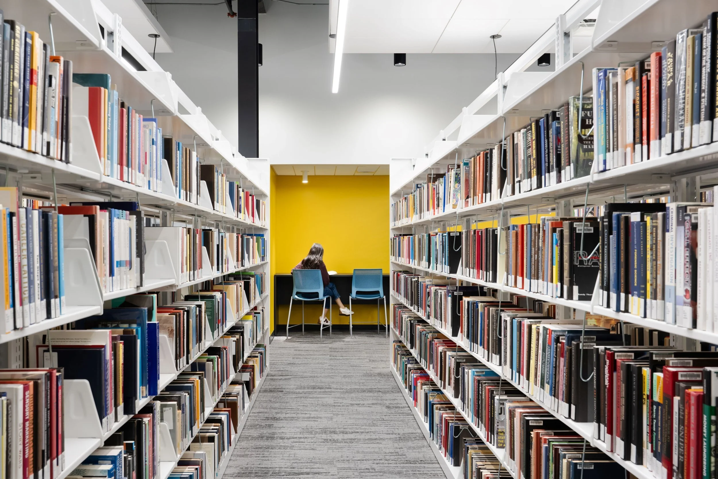 20-zaffere-library-the-stacks-with-a-yellow-study-alcove-at-the-end.jpg