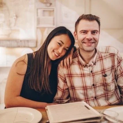 Smiling couple sitting at a table in a cozy home.