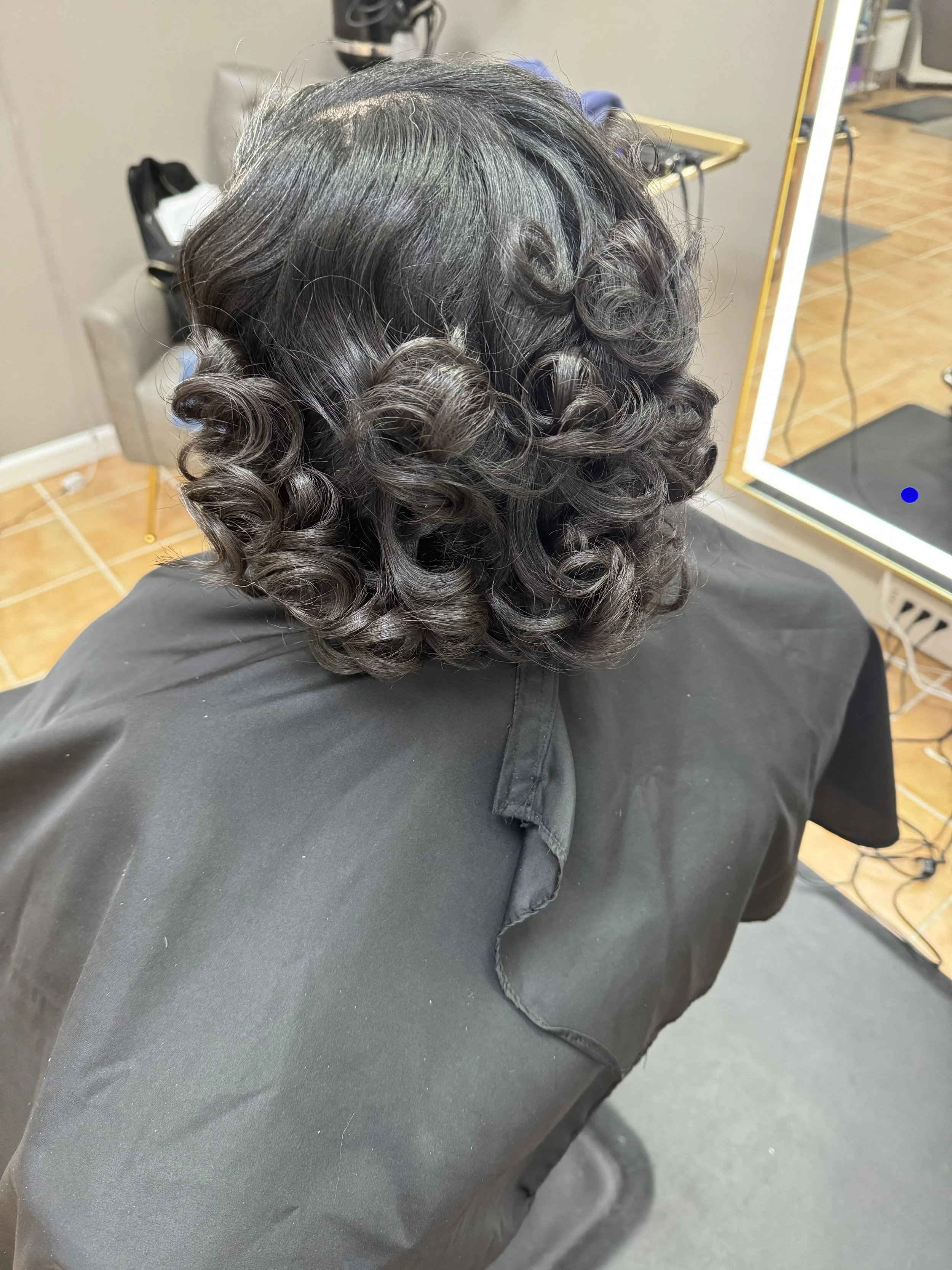 Deluxe Relaxer & Signature Finish

This experience restores smoothness and manageability while protecting the integrity of the hair.
A precision relaxer is followed by a therapeutic steam hydration treatment, nourishing scalp massage, and a maintenan