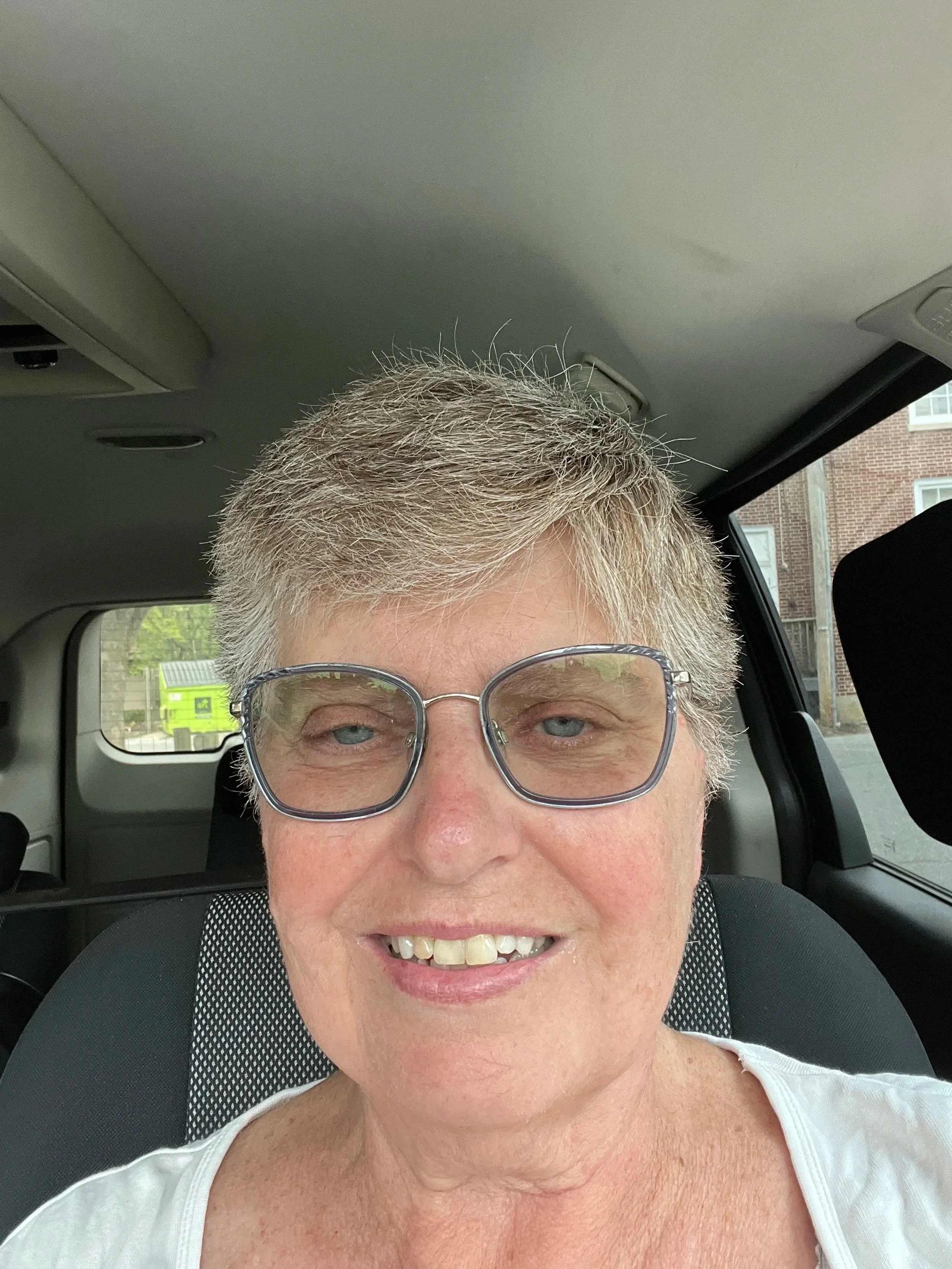 A woman woman short gray hair and glasses.