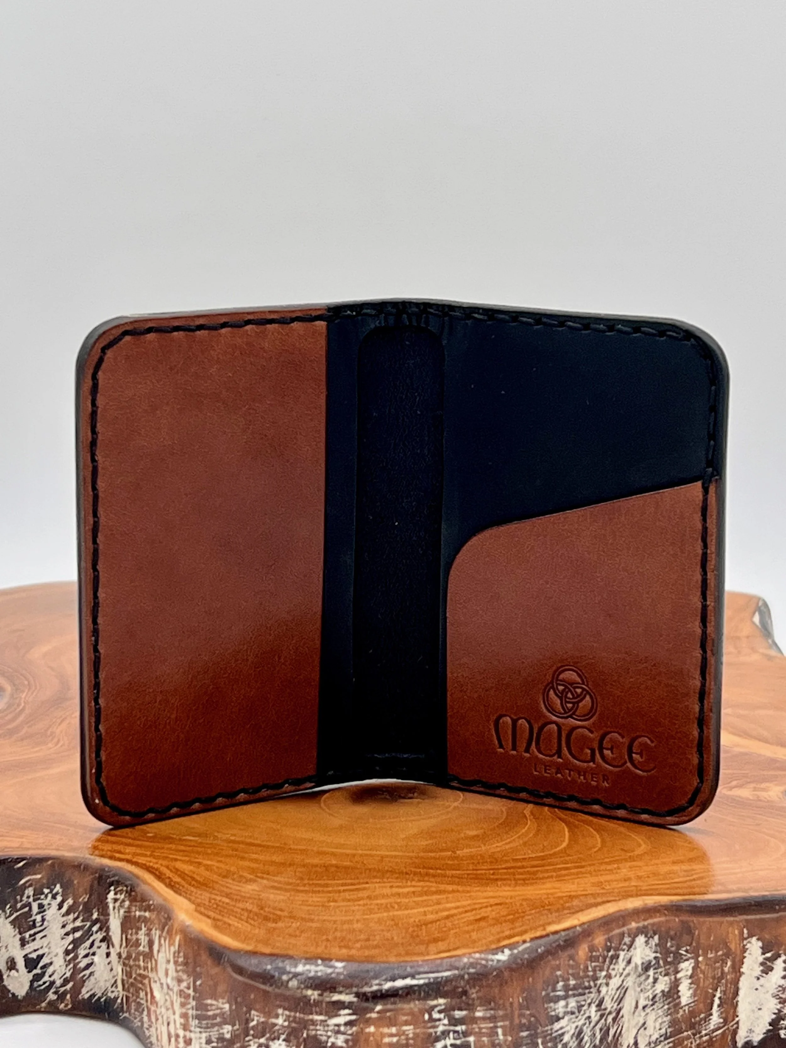 Open leather wallet with card slots, placed on a wooden surface.