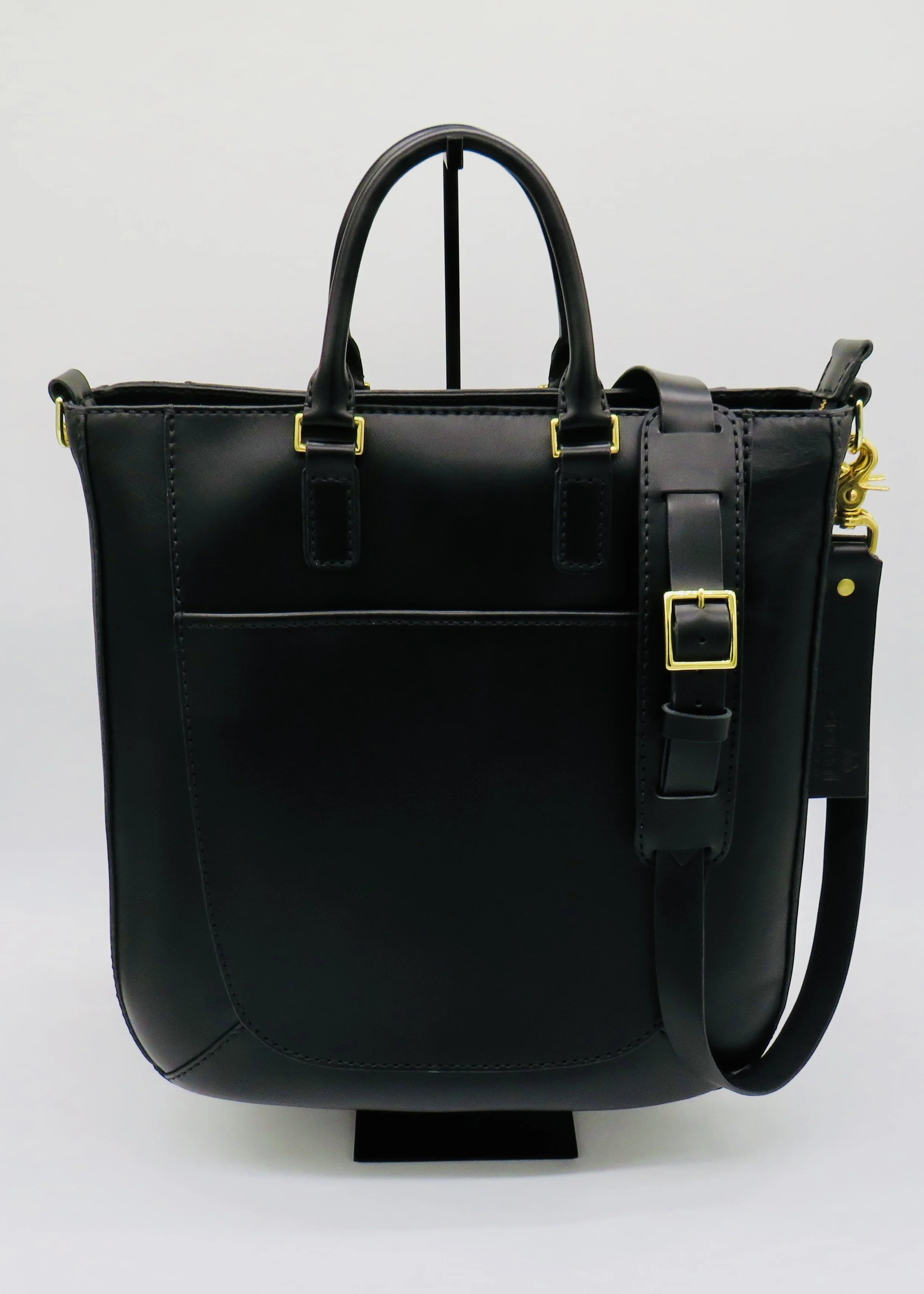Black leather handbag with gold hardware and adjustable strap, displayed upright against a plain white background.