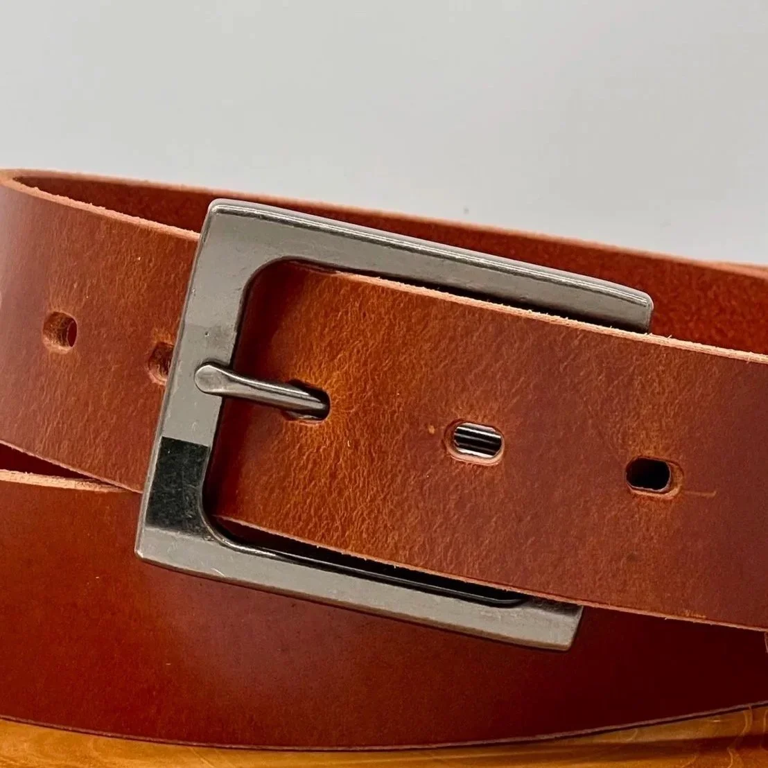 Close-up of a brown leather belt with a metal buckle.