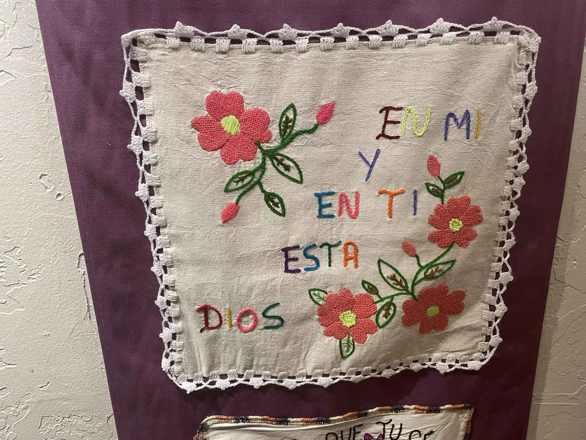Embroidered square with "En mi y en ti esta Dios" sewn onto it