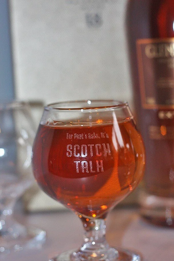 A small scotch glass with custom engraving that reads "Scotch Talk".