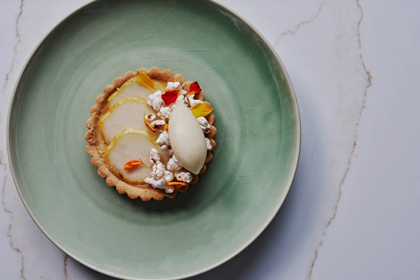 A Venezuelan classic reimagined &mdash; our ✨Quesillo Tart✨ features a creamy custard baked into a buttery shortbread crust, topped with pear sorbet and spiced caramel popcorn.

Captured beautifully by @andrewthomaslee 📸

#BarANA #ComingSoon #Atlant