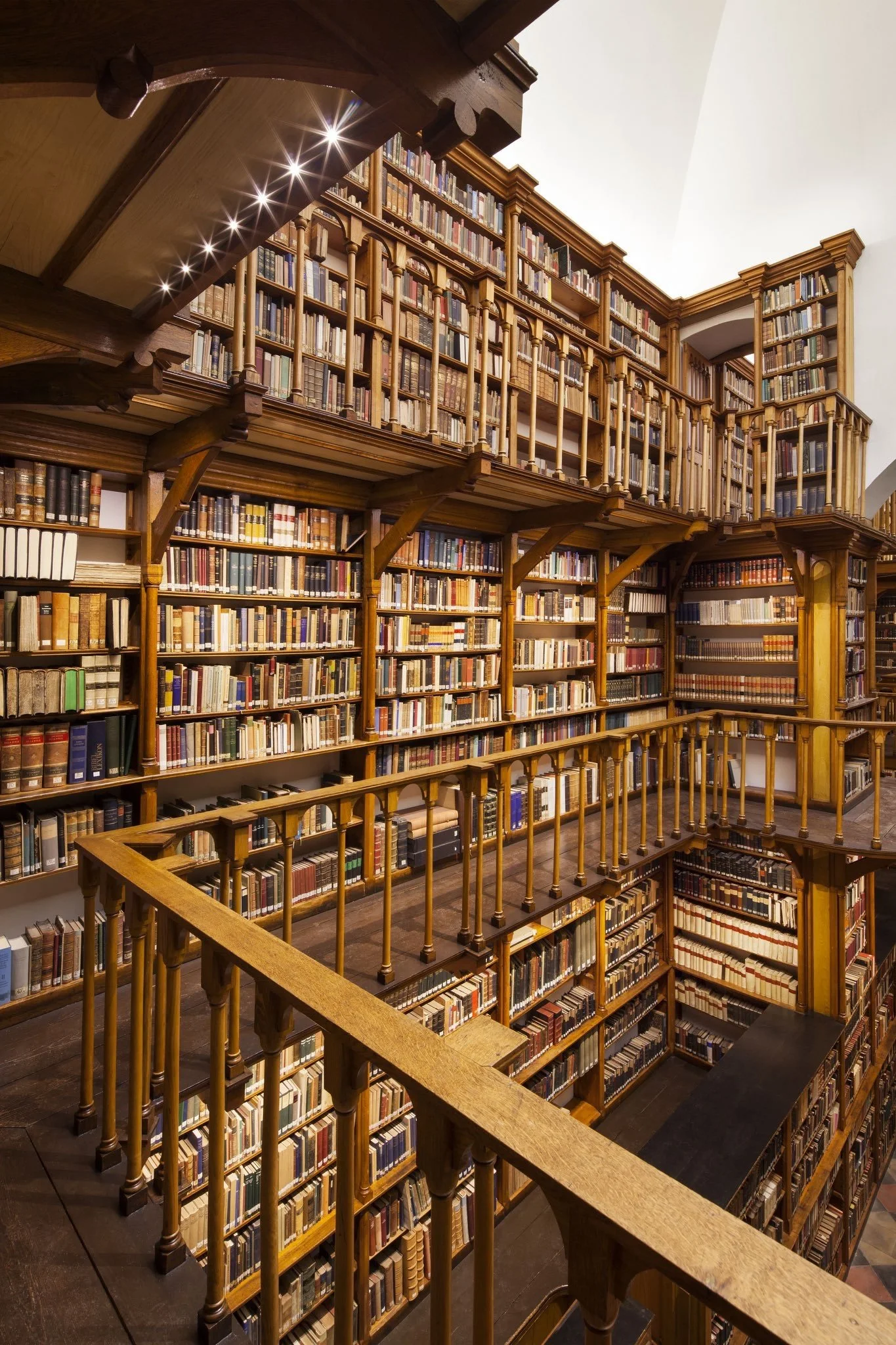 As pontes de madeira e estantes centenárias da Biblioteca de Maria Laach. Um espaço de silêncio, estudo e beleza monástica.