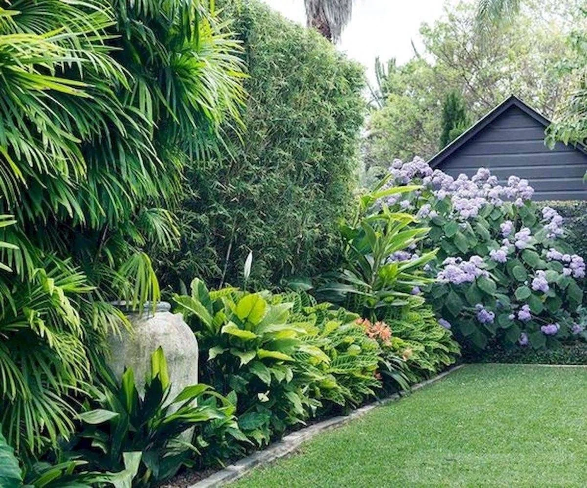 Um jardim tropical com bordadura de folhagens.