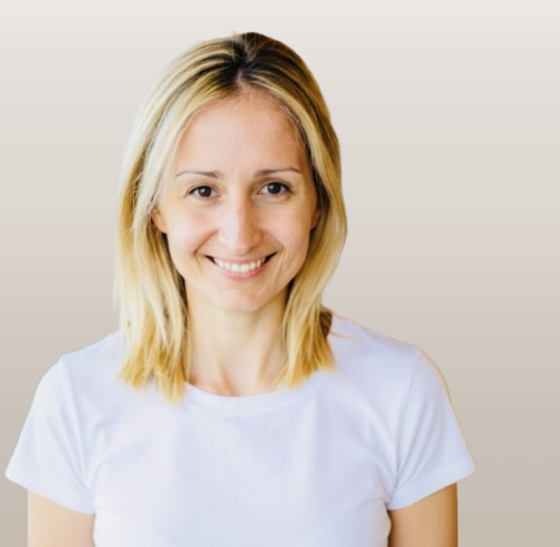 A woman with blonde hair smiling, wearing a white t-shirt against a plain background. Paula Coutinho Registered Clinical Counsellor with the BC Association of Clinical counsellors speaks Portuguese and English