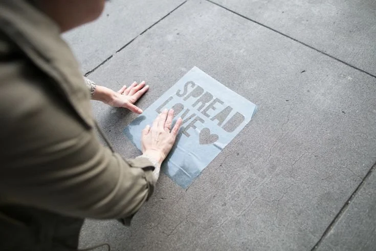 Sidewalk stencil advertising applied to high-traffic pedestrian walkways
