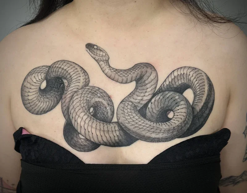 snake tattoo on woman's chest by Ella Baer
