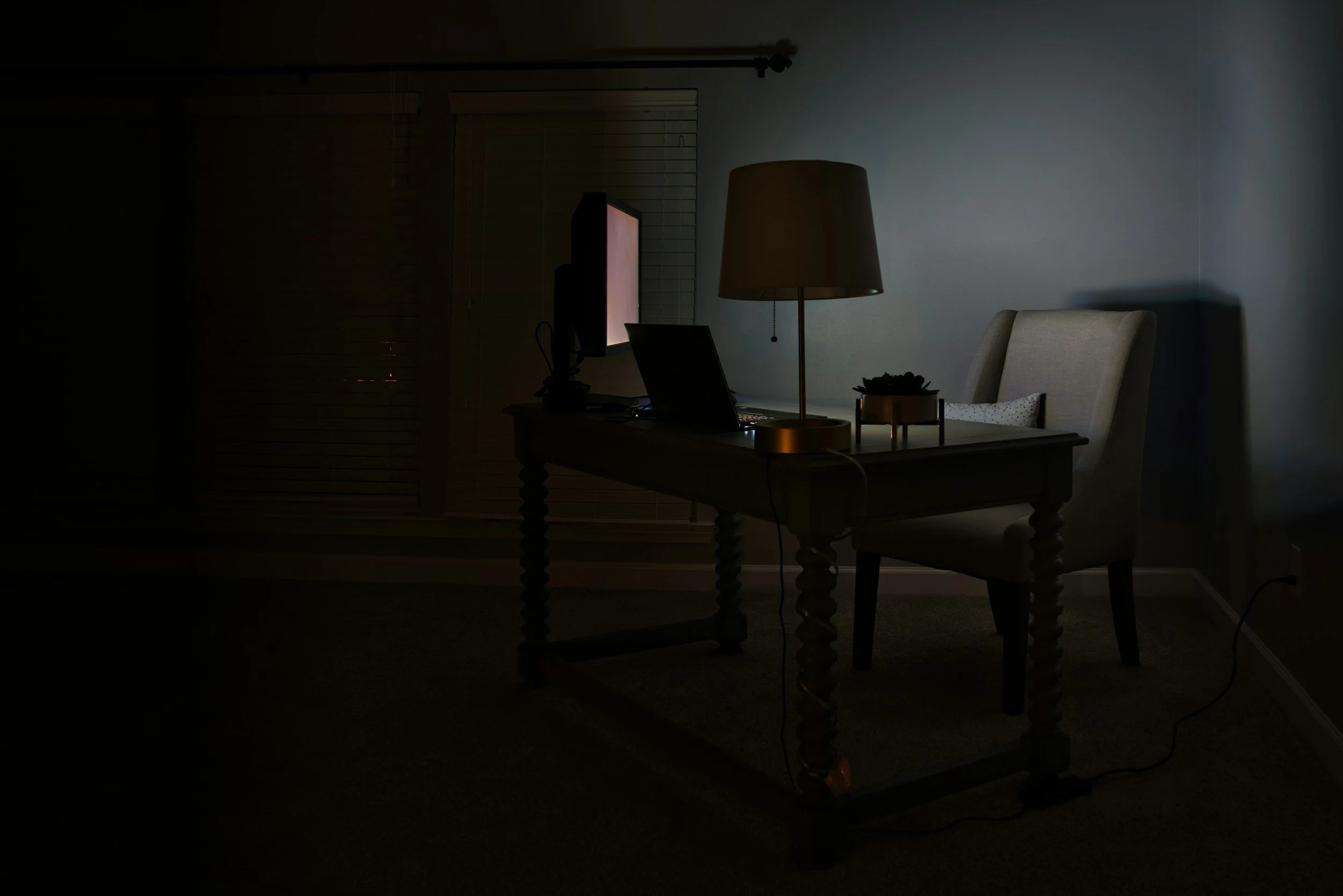 computer at desk in an empty dark room