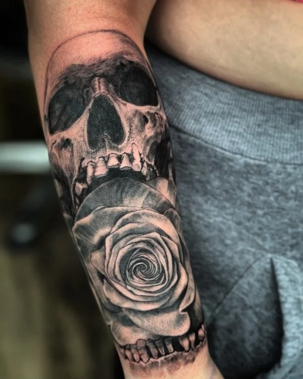 black and gray skull with rose tattoo by Vic Tamian