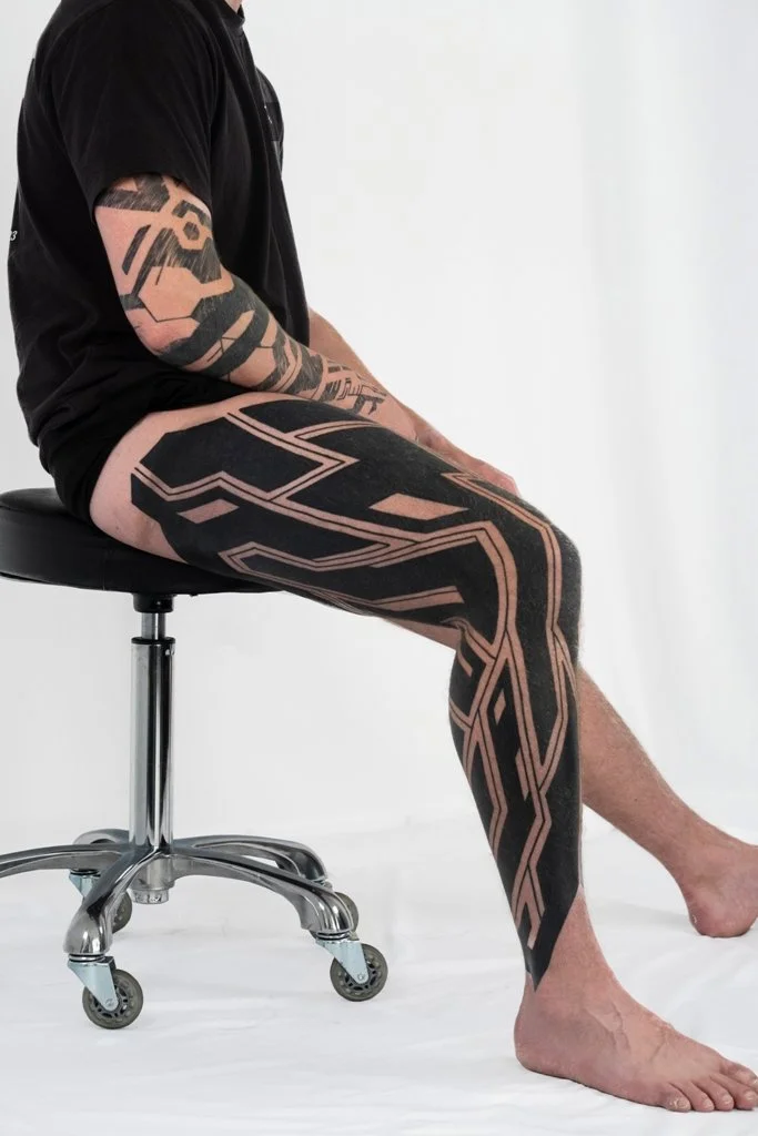 tattoo artist Kevin Ligabue - heavy black and gray leg tattoo