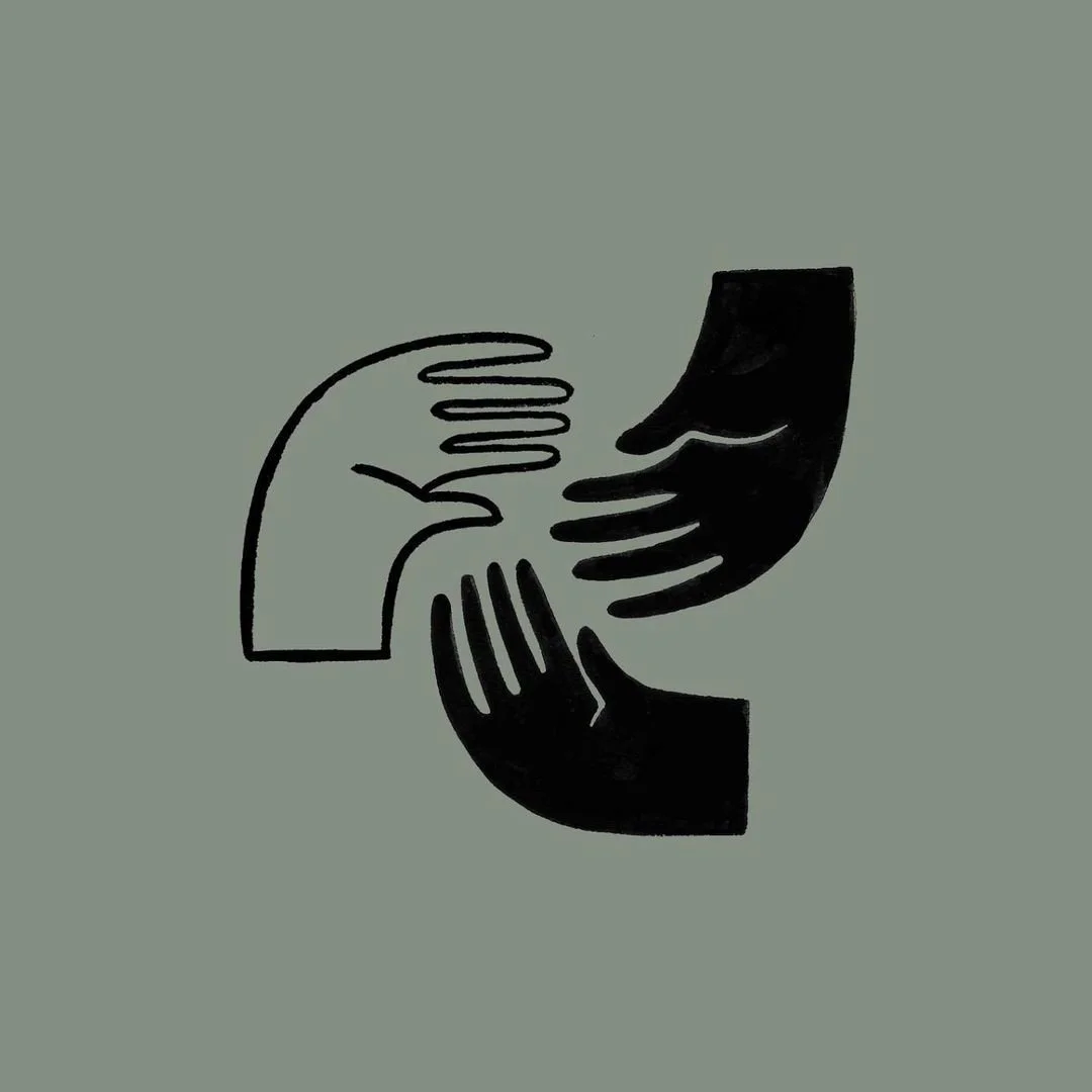 Landscape of a large lake surrounded by rolling grassy hills and mountainous terrain under a cloudy sky.