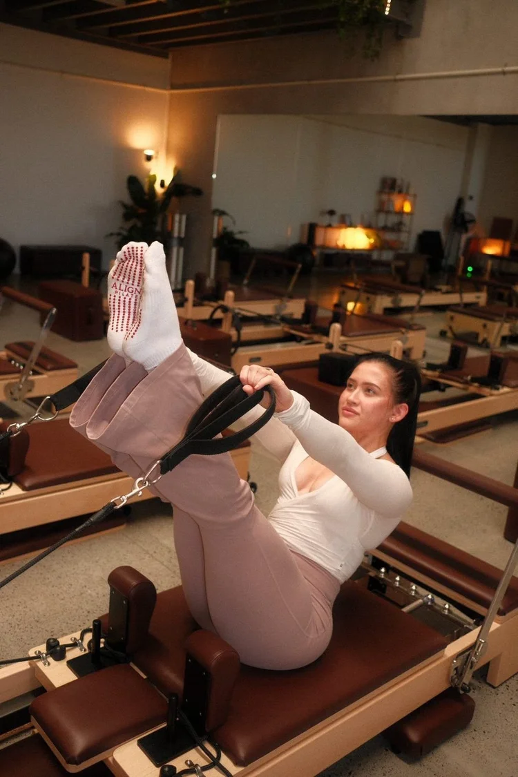 A woman holding a teaser on the Reformer