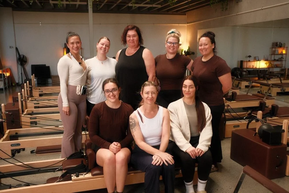 A group of smiling women at ALIGND Pilates