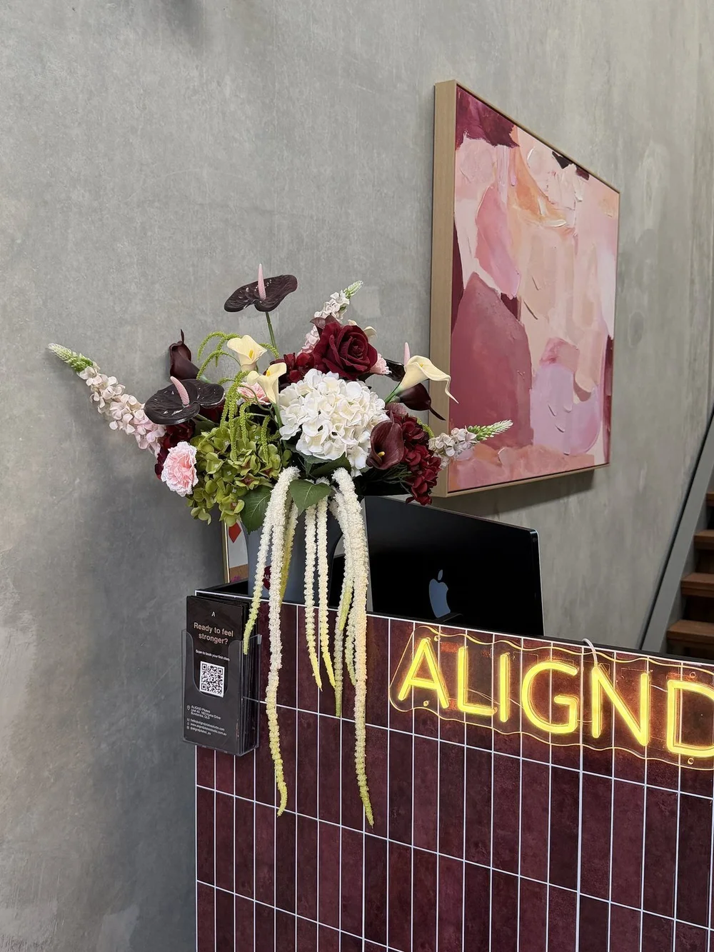 The ALIGND reception with flowers and neon sign