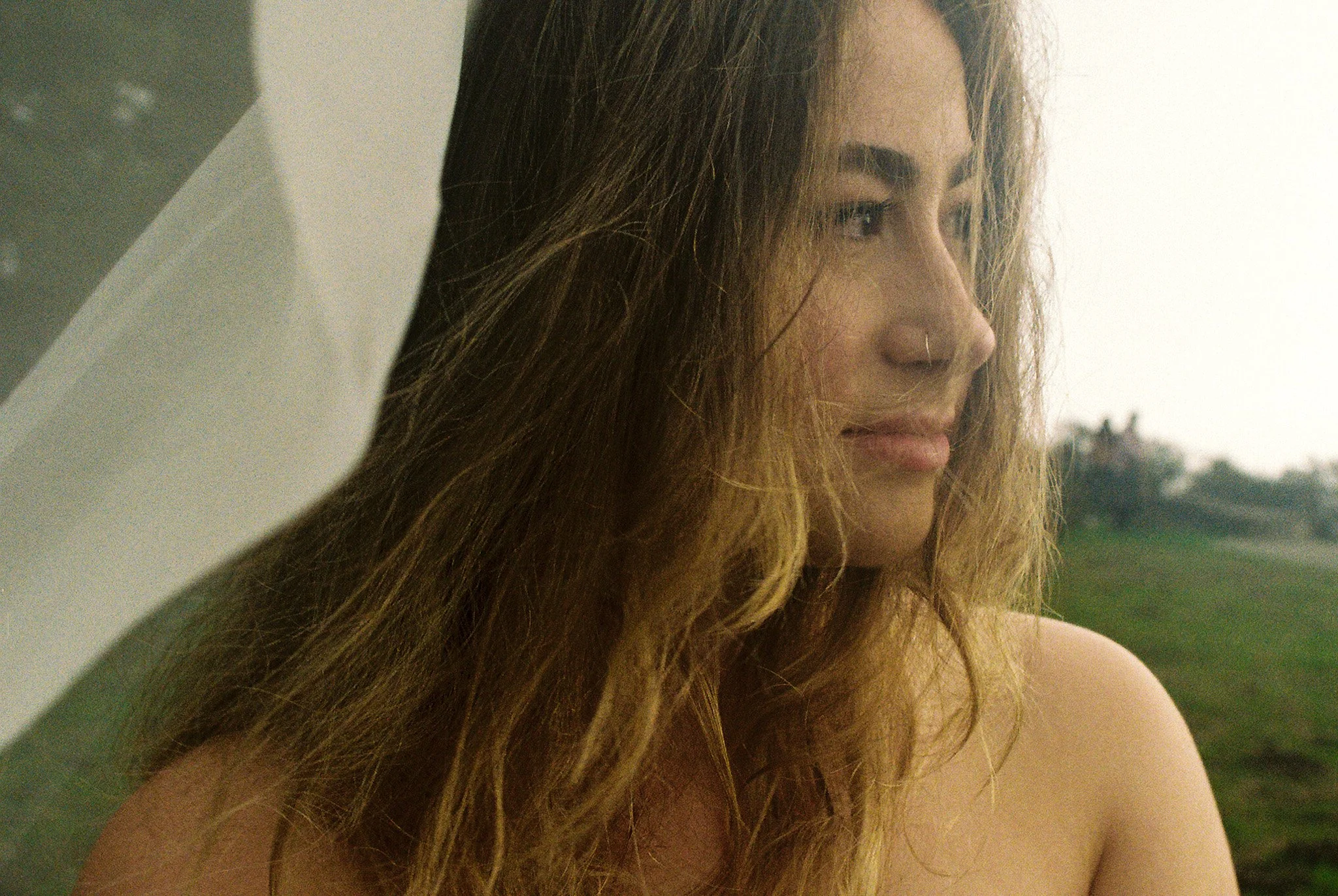 Close-up of a woman with long wavy hair looking to the side.