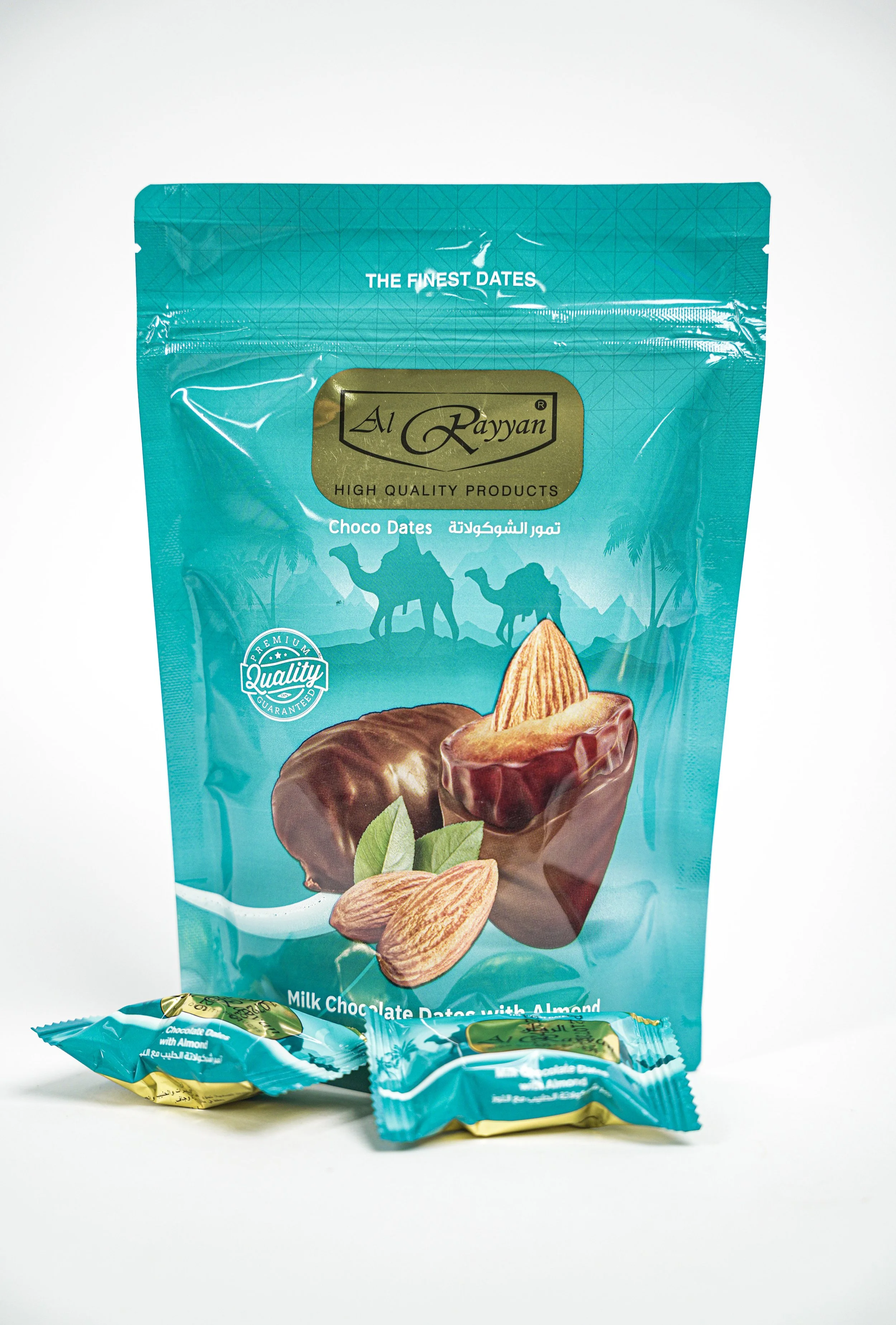 A teal package of Al Rayan Choco Dates with almonds, featuring a picture of dates and almonds on the front. Two small wrapped chocolates are in front of the package.