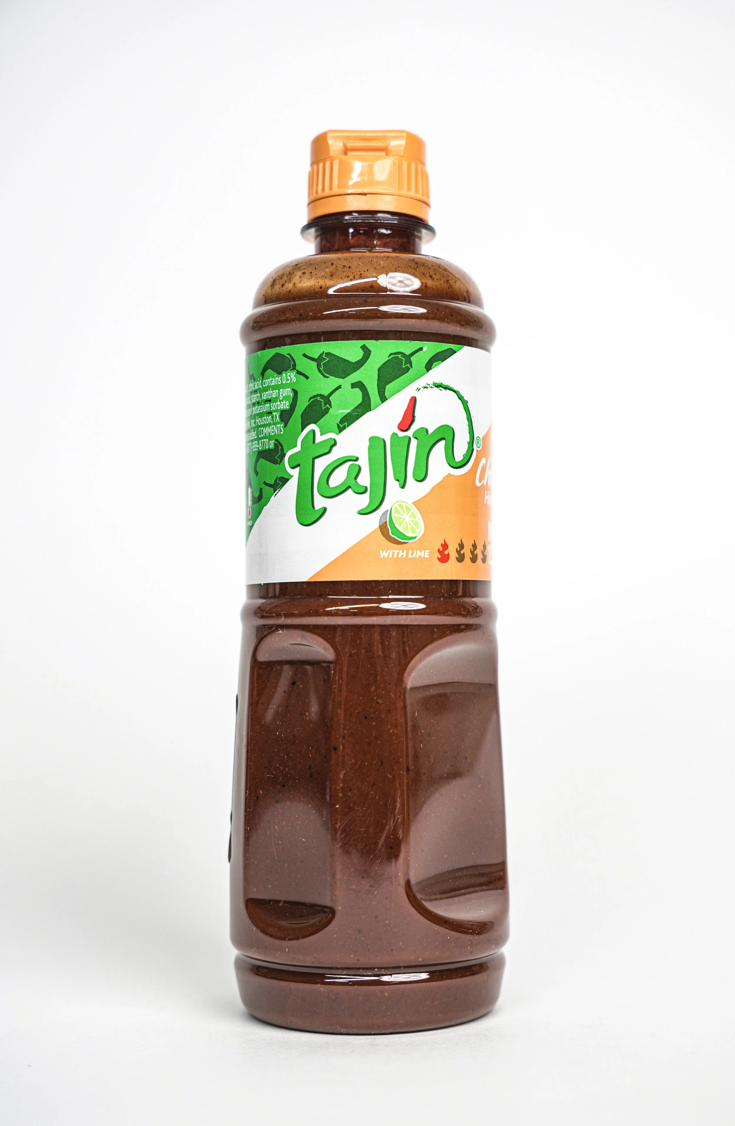 A plastic bottle of Tajín chili-lime seasoning with a green, white, and orange label, featuring a lime slice and the text 'with lime'.