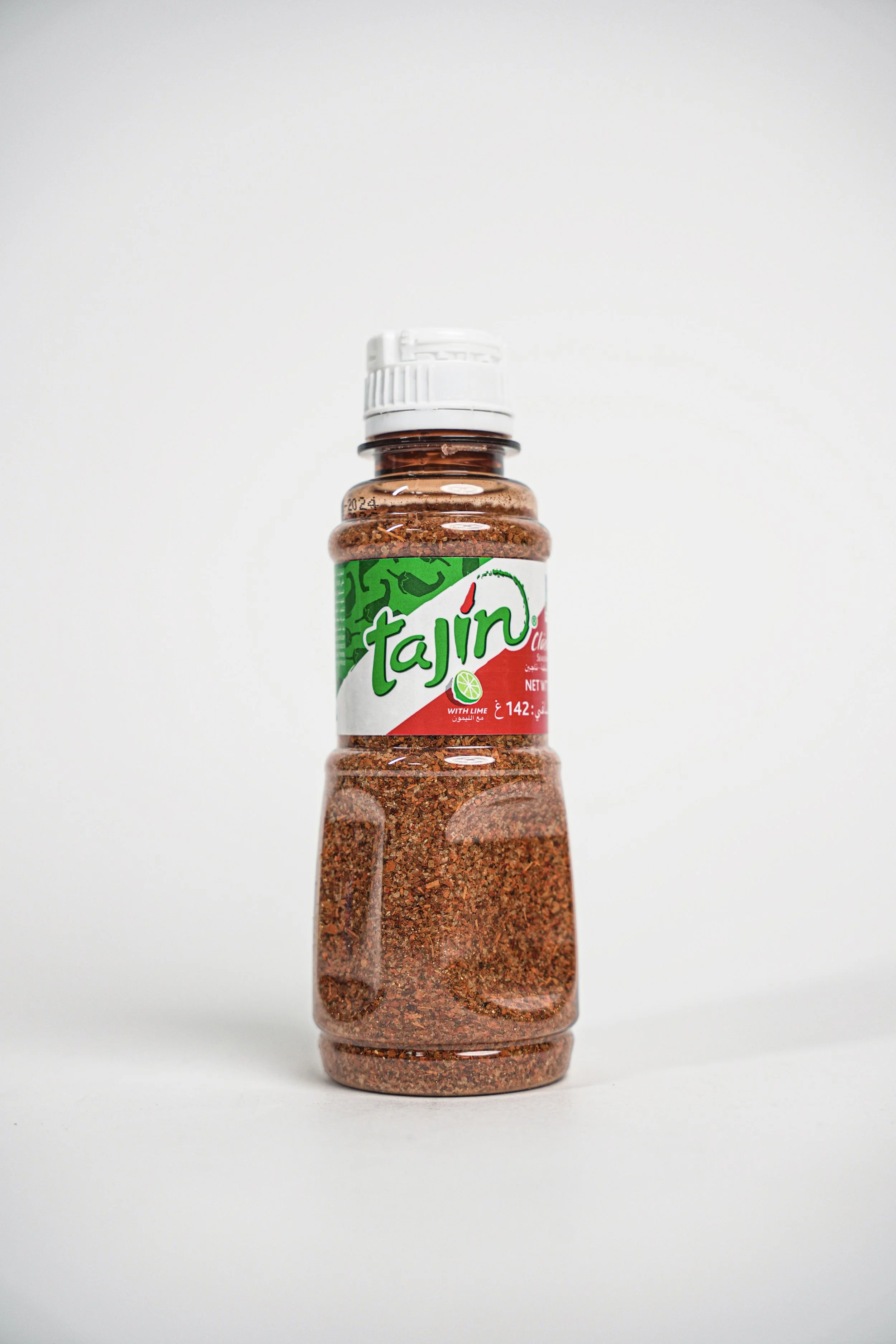 A bottle of Tajin chili powder with lime flavor on a white background.