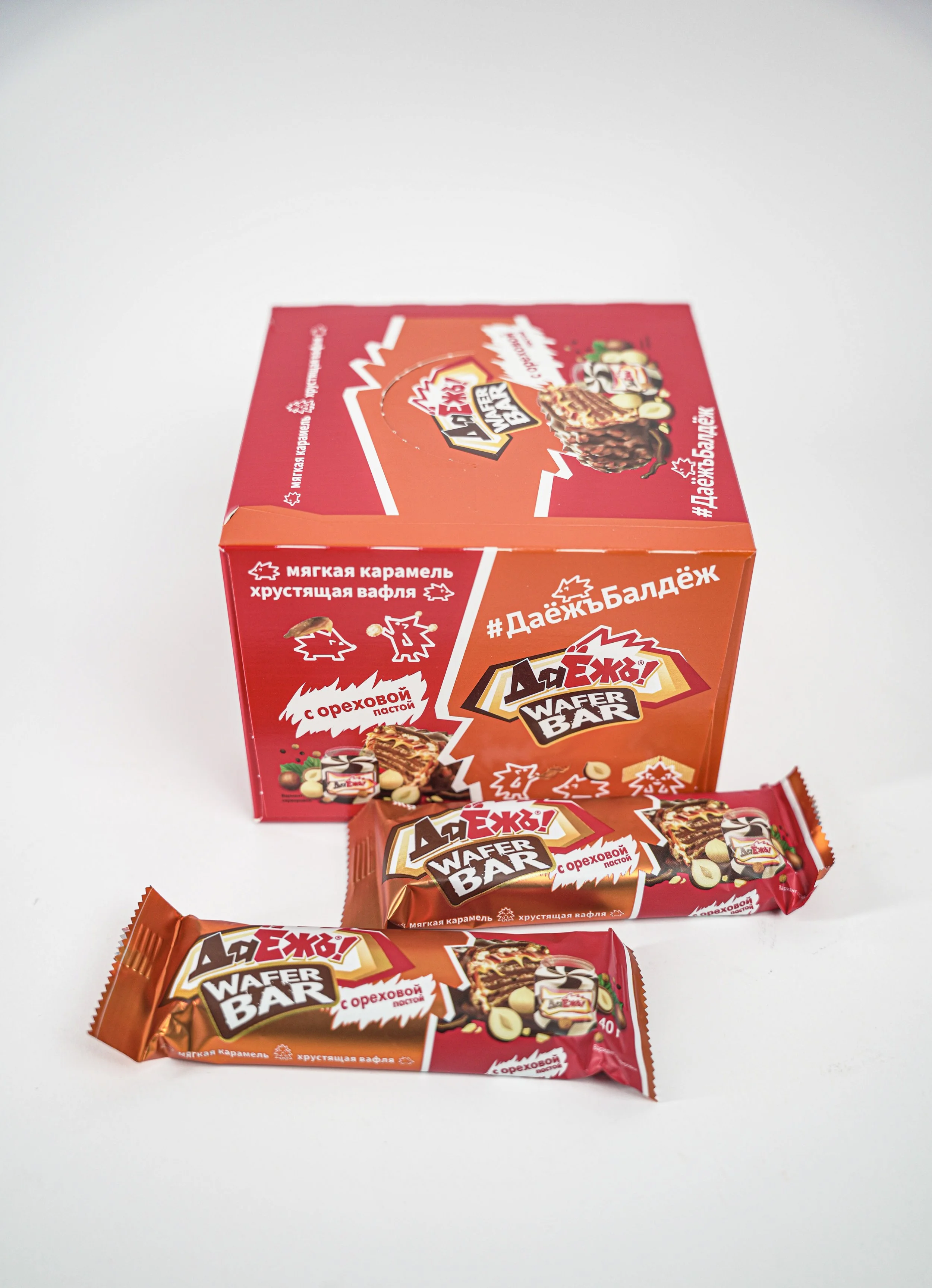 Russian wafer snacks with individual wrappers in front, featuring caramel flavor and nut toppings