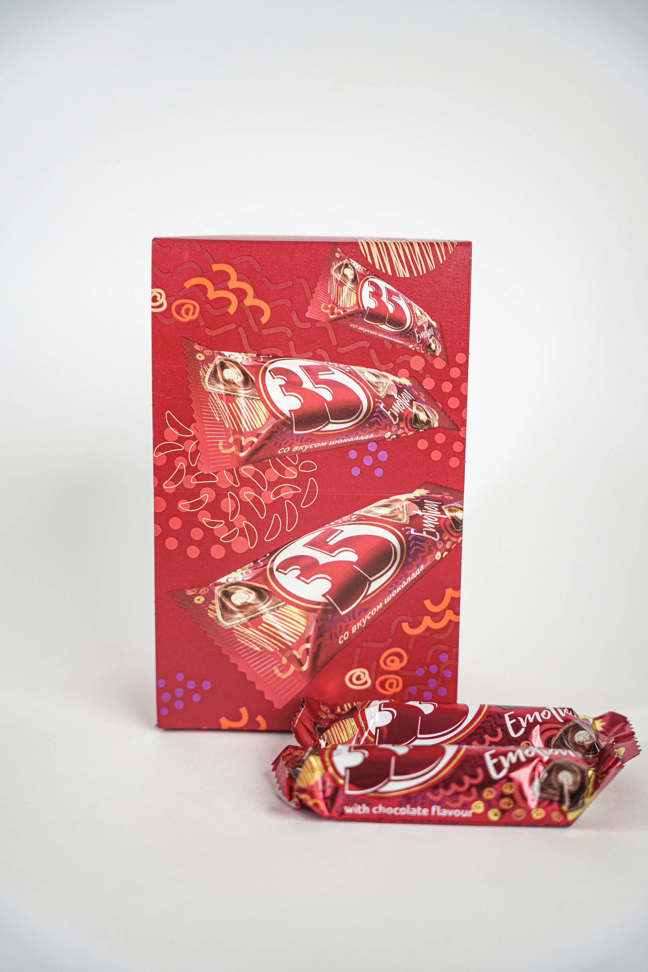 One red box and two individual wrapped chocolates with the number 35, with colorful patterns and text indicating chocolate flavor.