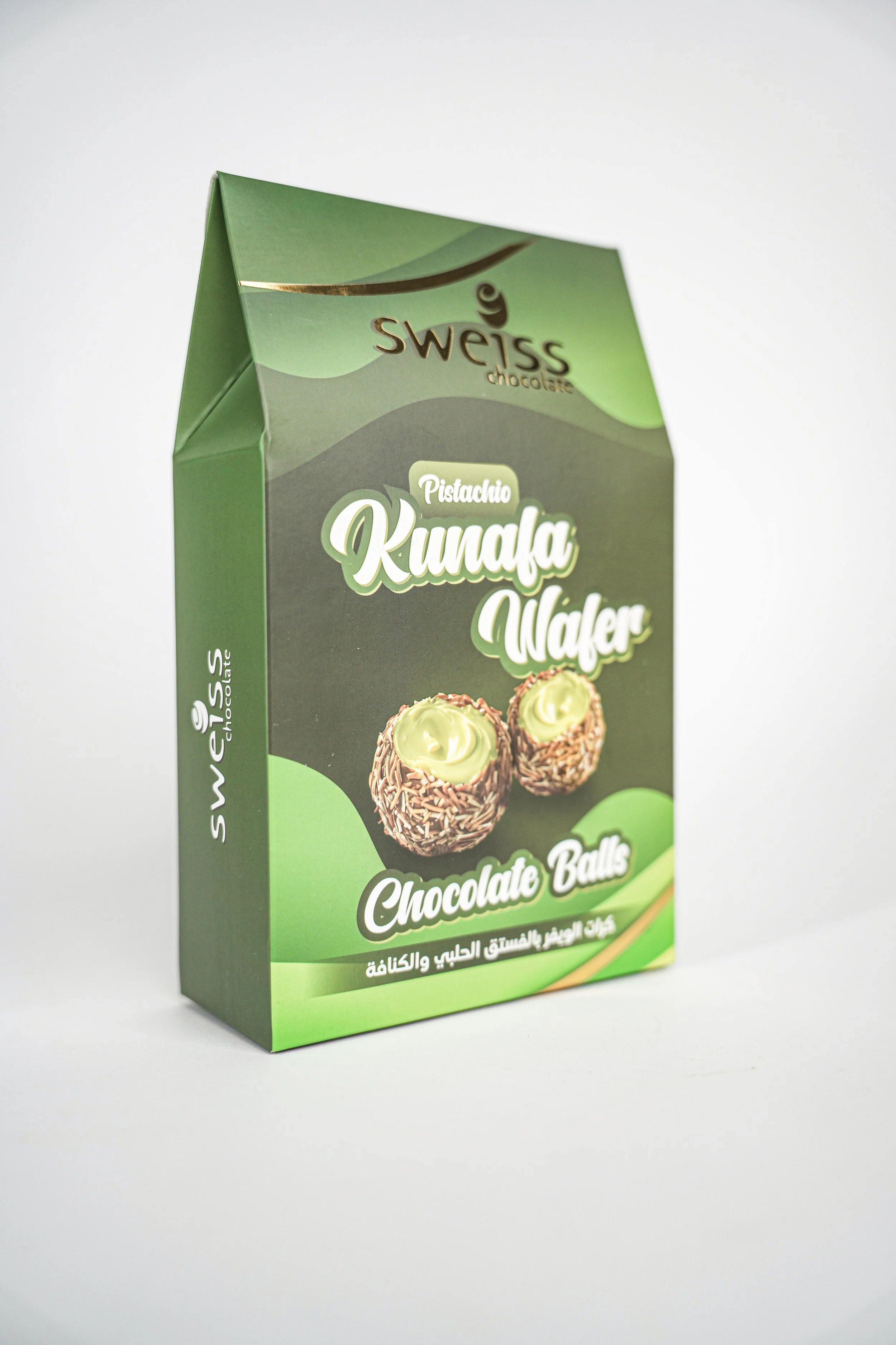 A green packaging box of Swiss chocolate pistachio kunafa wafer chocolate balls, with an image of two chocolate balls filled with pistachio cream on the front.