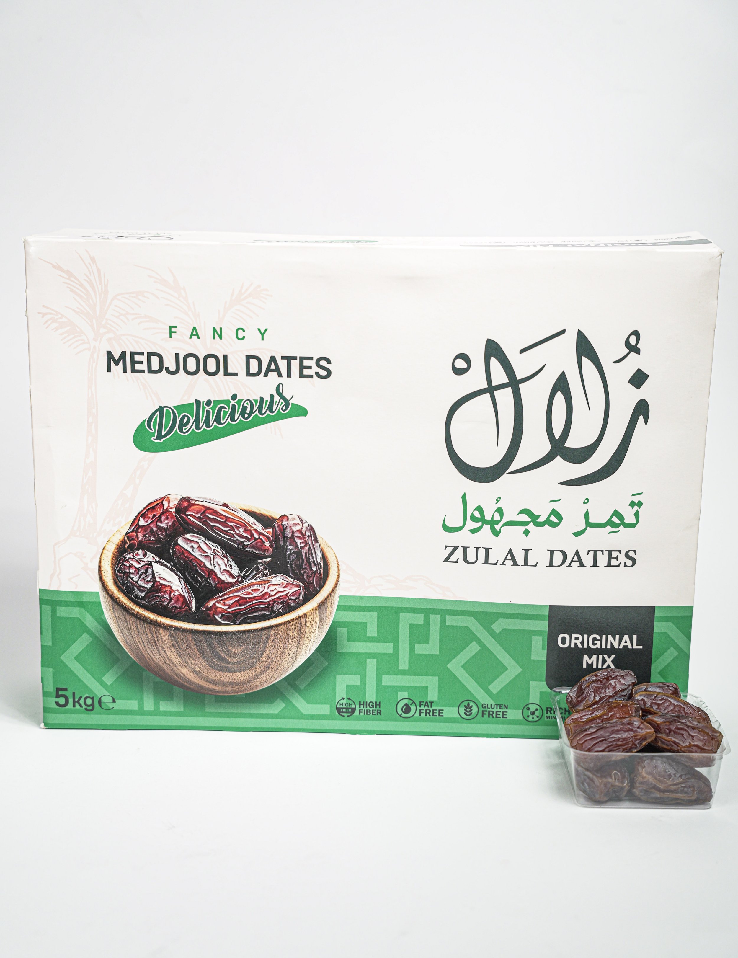 A 5 kg box of Medjool dates labeled 'Fancy Medjool Dates Delicious' with Arabic script, a bowl of dates on the box, and a small tray of dates in front of the box.