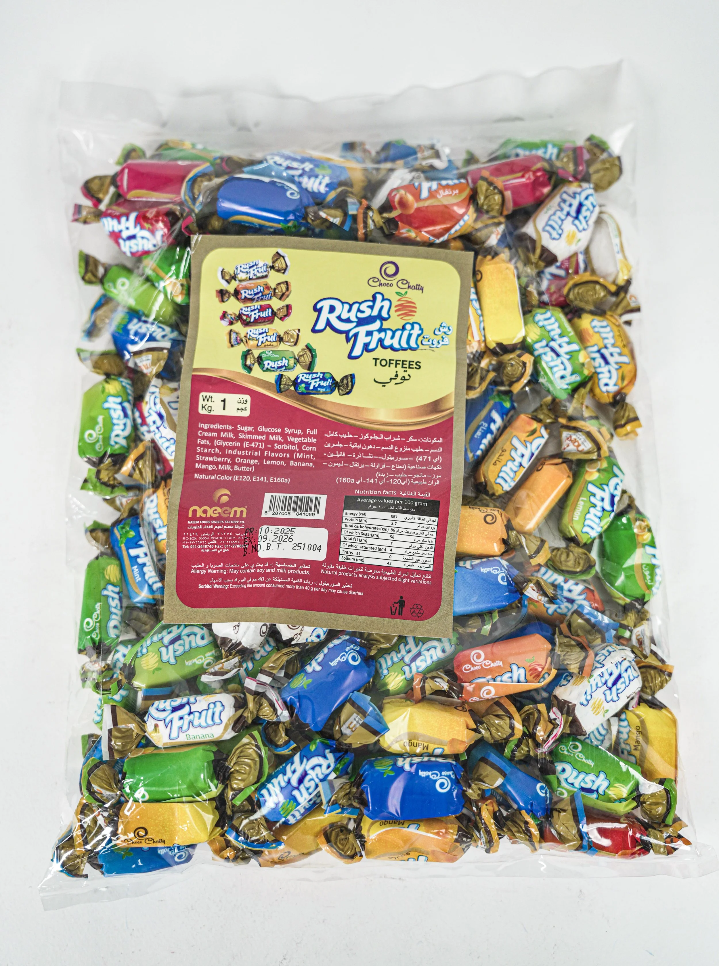 A clear plastic bag filled with assorted rush fruit toffees in colorful wrappers, with a label featuring the brand name and product details.