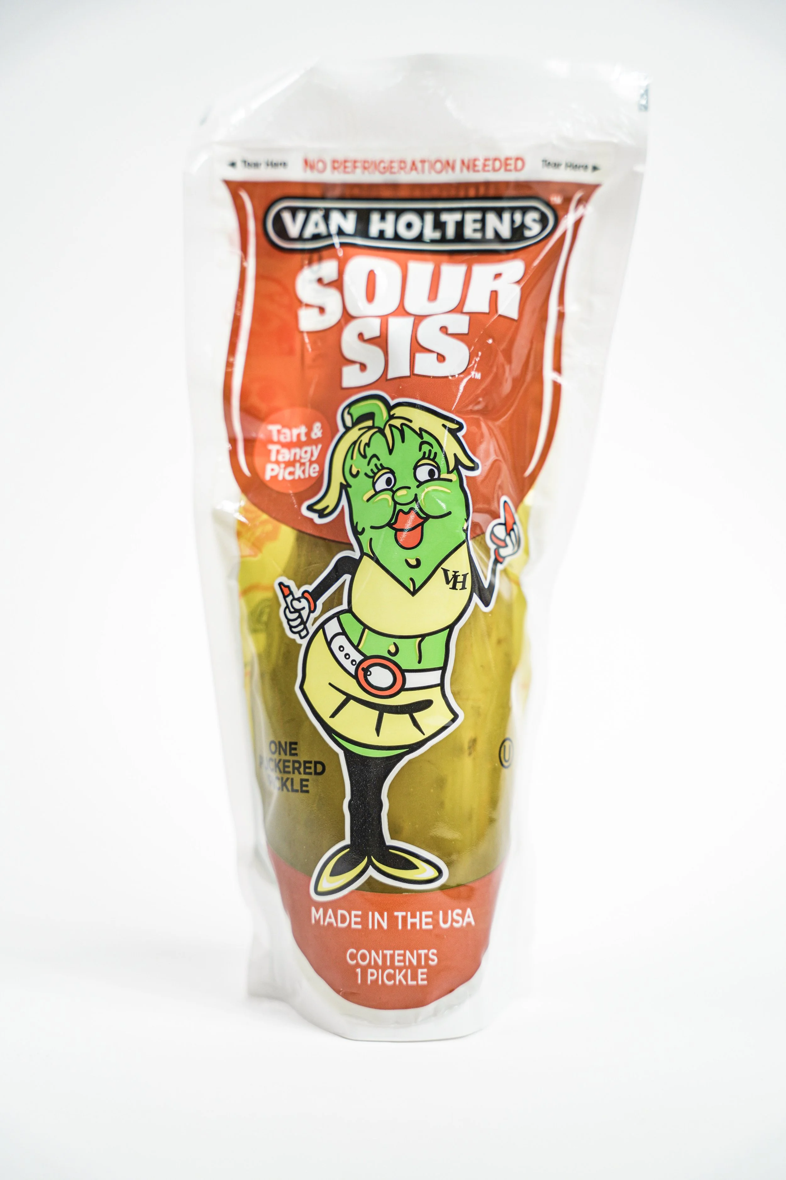 A package of Van Holten's Sour Sis pickles with a cartoon pickle character on the front, featuring a green pickle with a smiling face, dressed in a yellow top and black skirt, holding two pickles in each hand, against a white background.