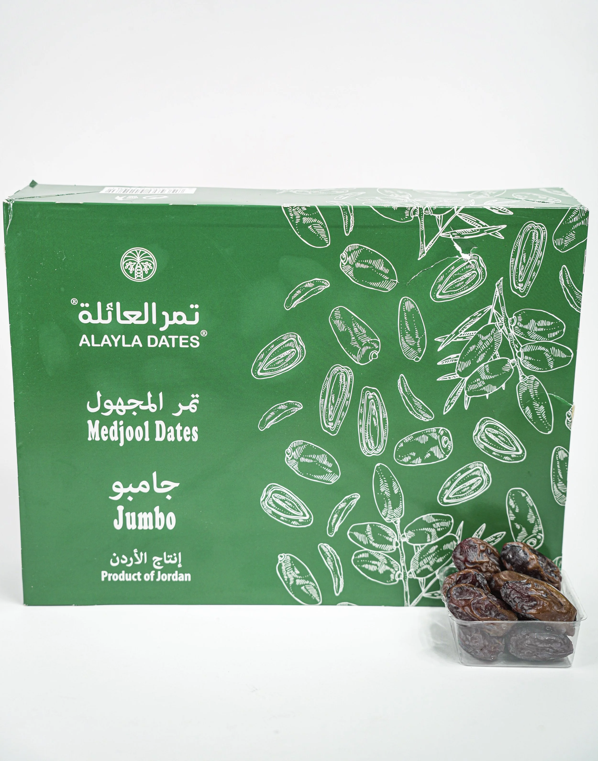 Green box of Alayla Dates with white illustrations of date seeds and branches, a small container of Medjool dates in front of it.