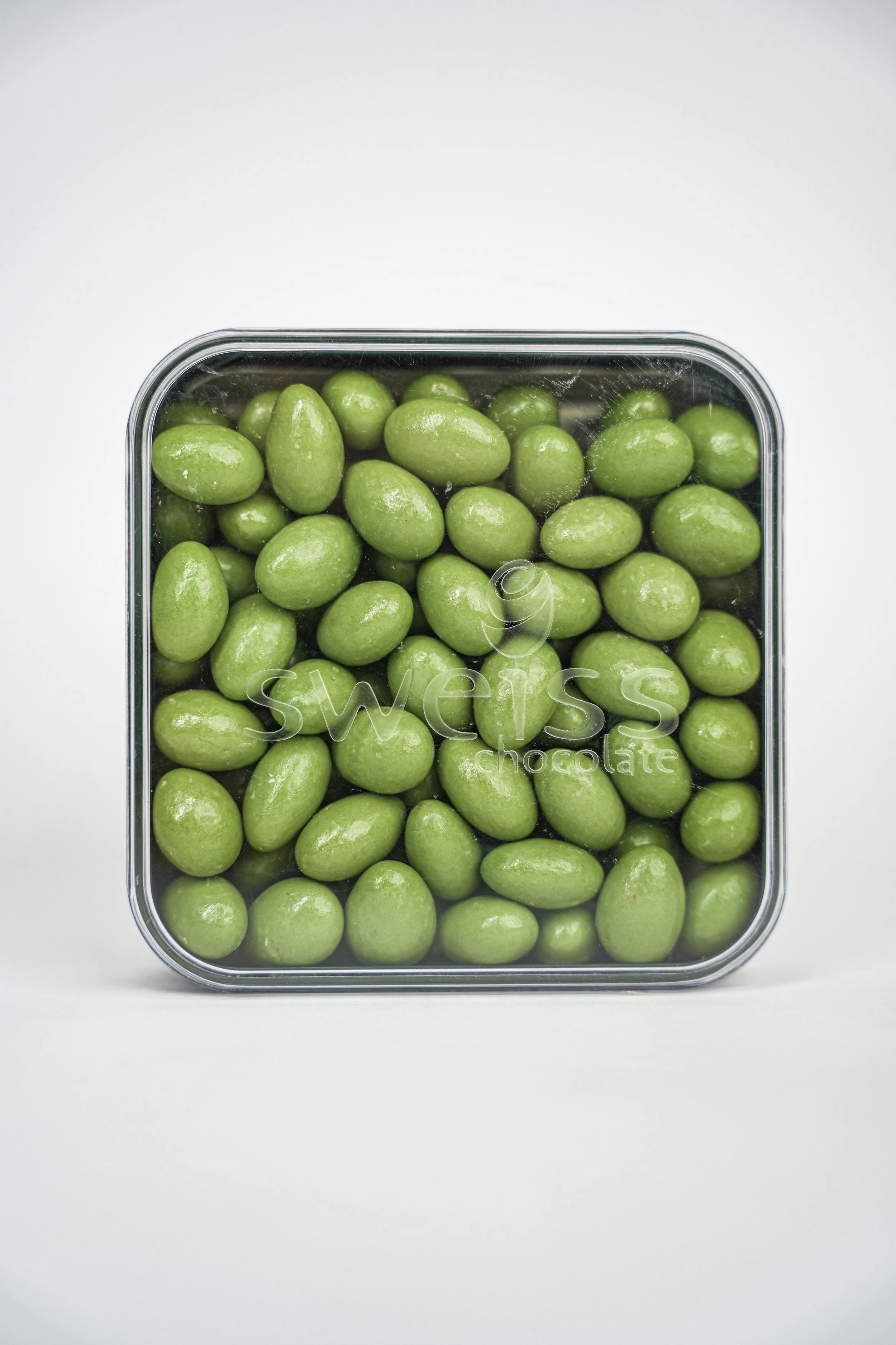 A container with green chocolate-covered candies labeled 'Swiss chocolate'.