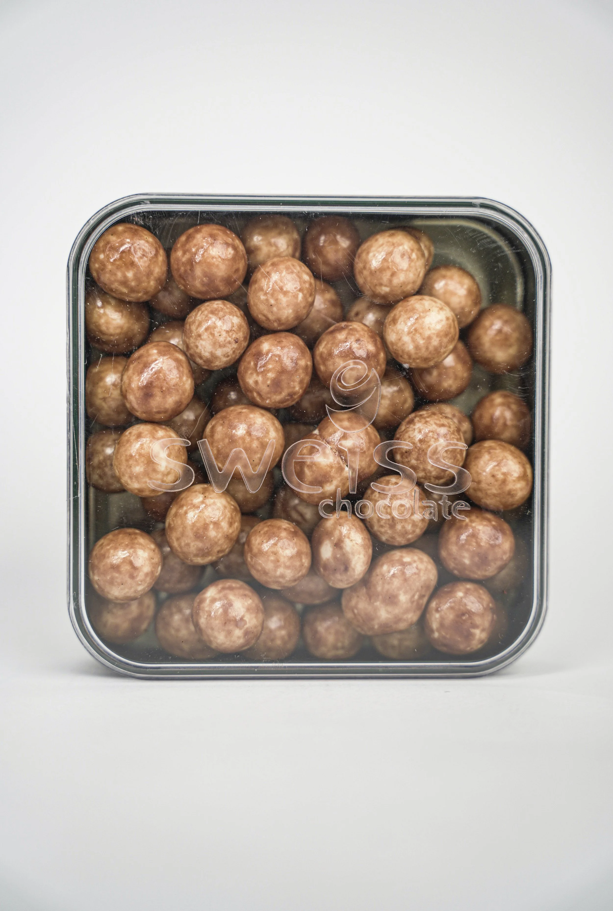 A clear plastic container filled with round chocolate-covered candies labeled 'Swissy chocolate' on the front.