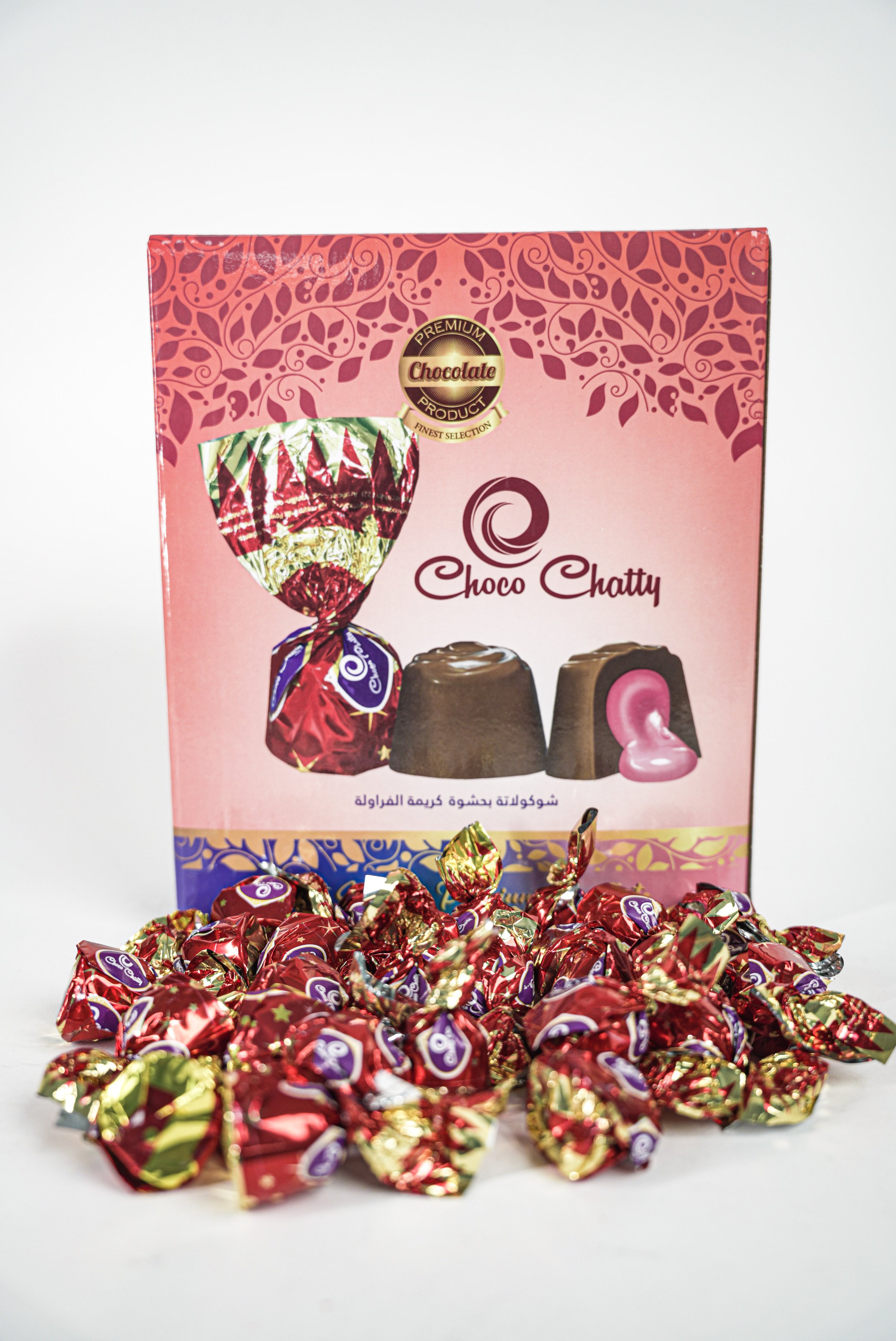 Pink box of Choco Chatty chocolates with individually wrapped candies in red and gold foil in front.
