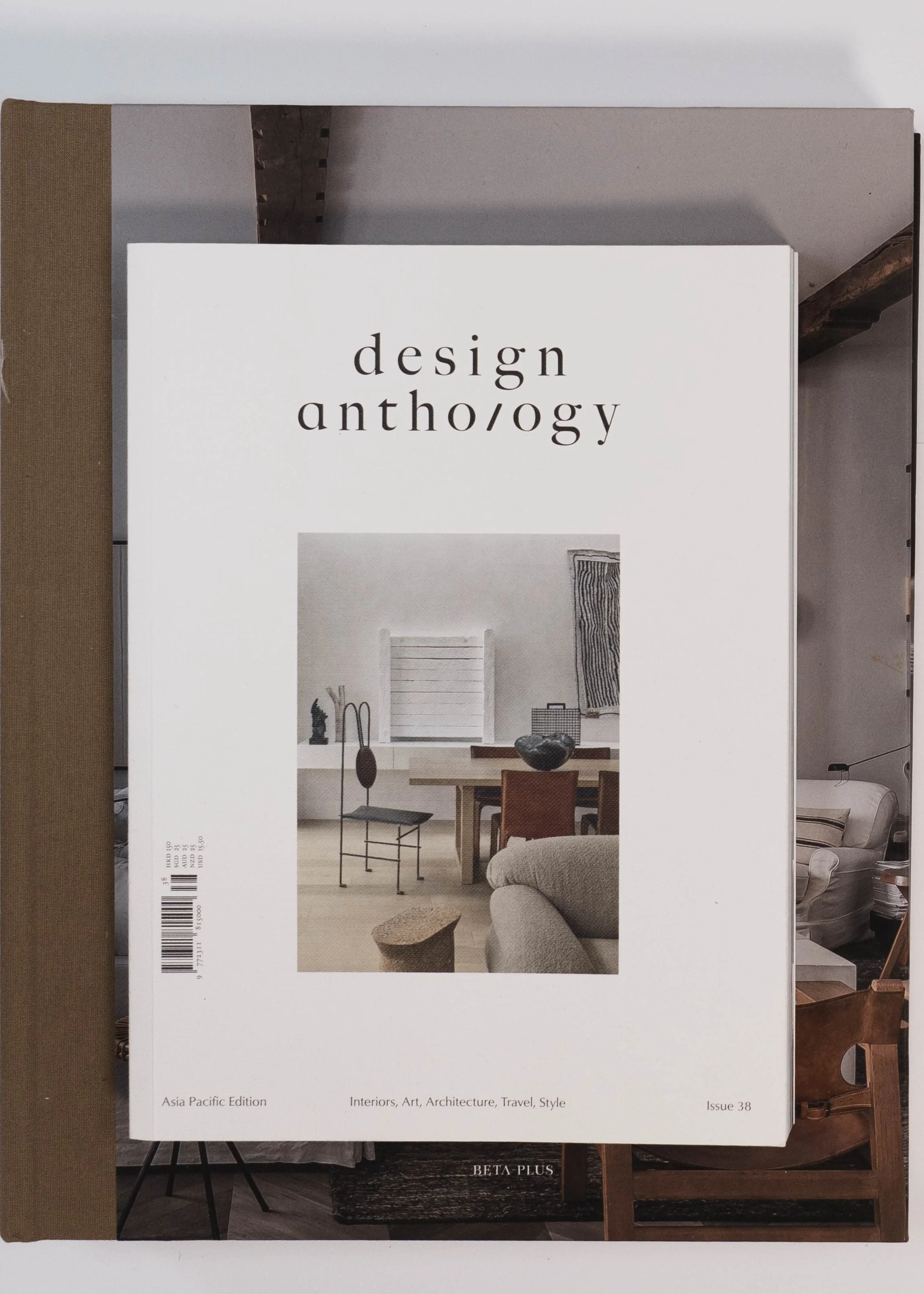 Cover of 'design anth/o/gy', an interior design magazine featuring a minimalist living room with a table, chairs, and wall art.