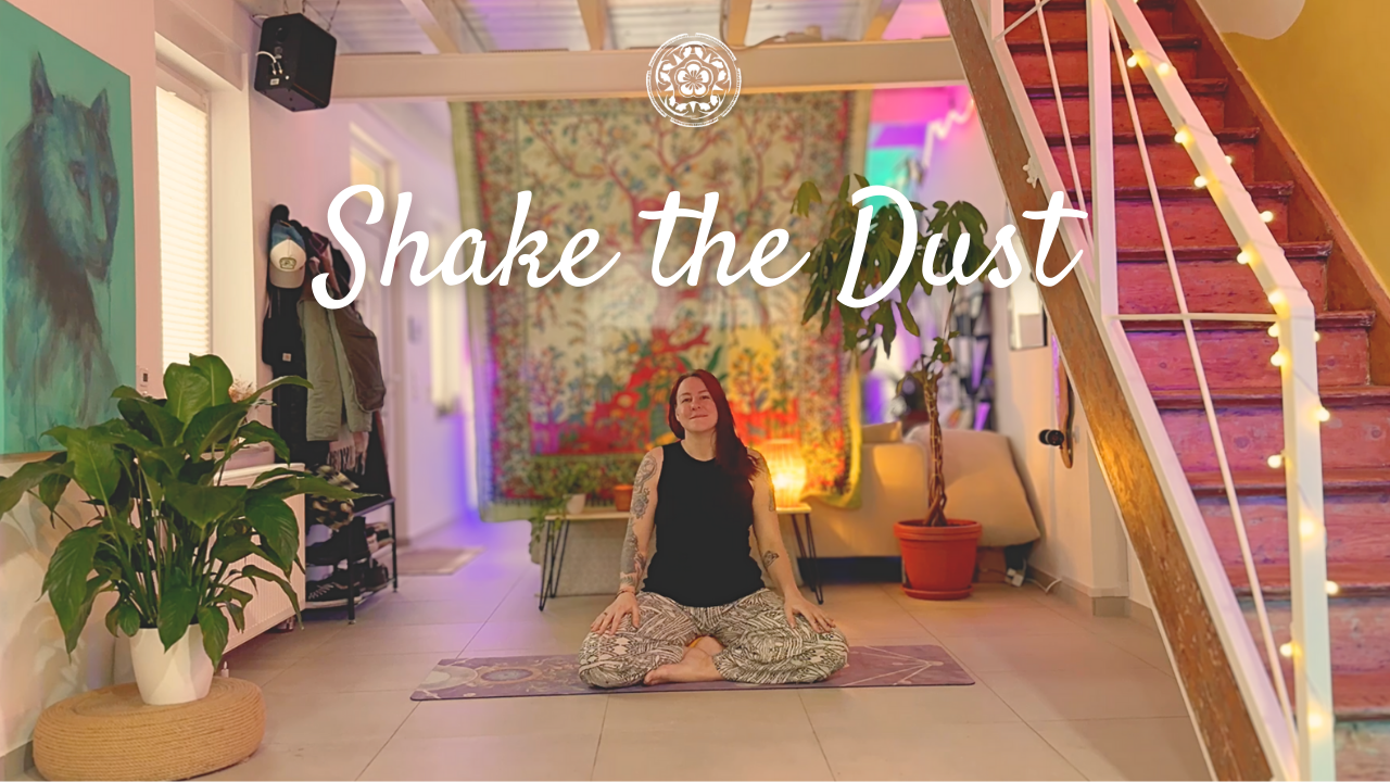 Eine Frau sitzt in einer meditativen Haltung auf einem Yogamatte in einem Wohnzimmer. Im Hintergrund sind Wandkunst, Pflanzen und eine Treppe mit Lichterketten. Der Raum ist gemütlich und farbenfroh gestaltet.