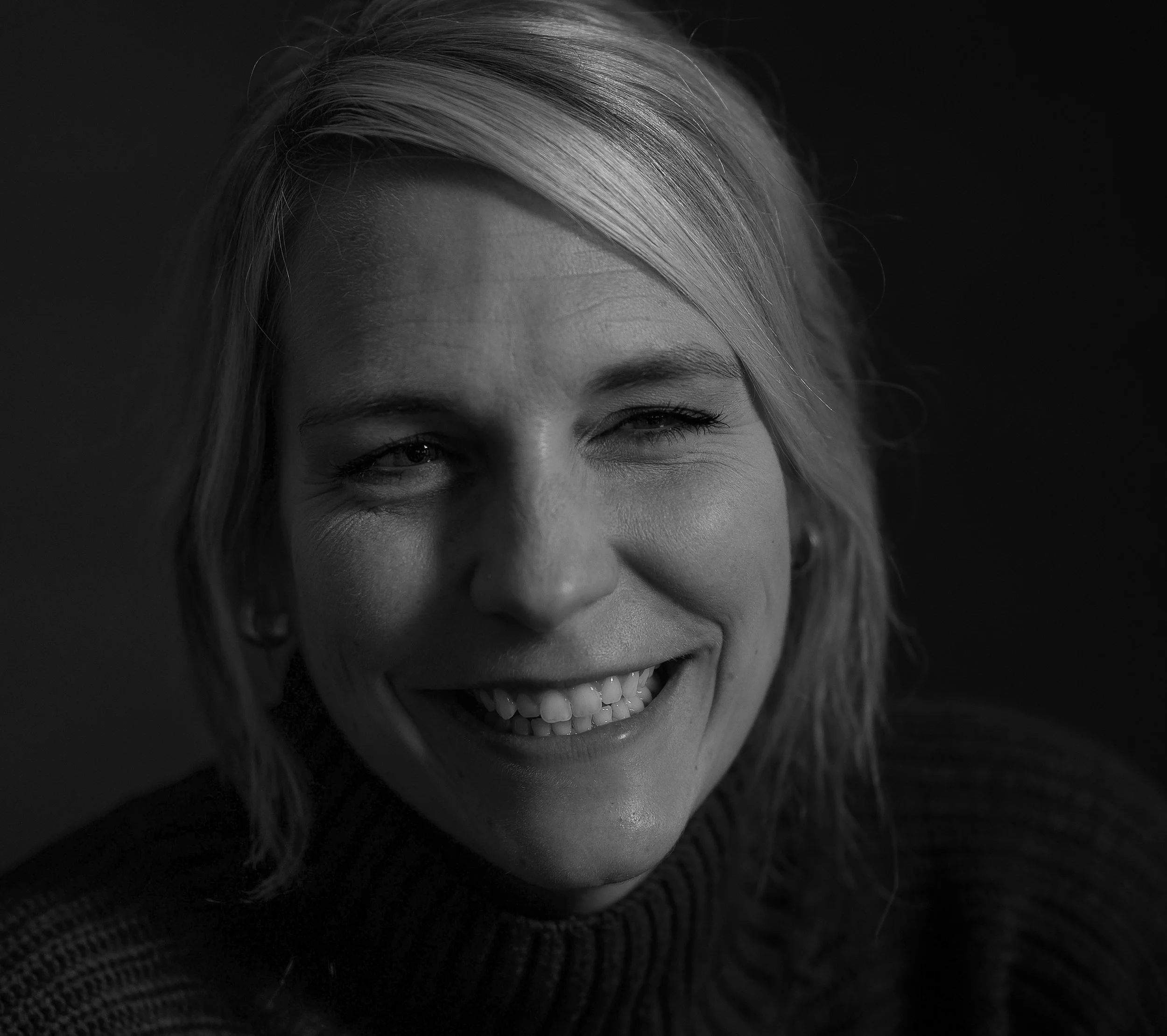 Lächelnde blonde Frau in Nahaufnahme, schwarz-weiß Porträt