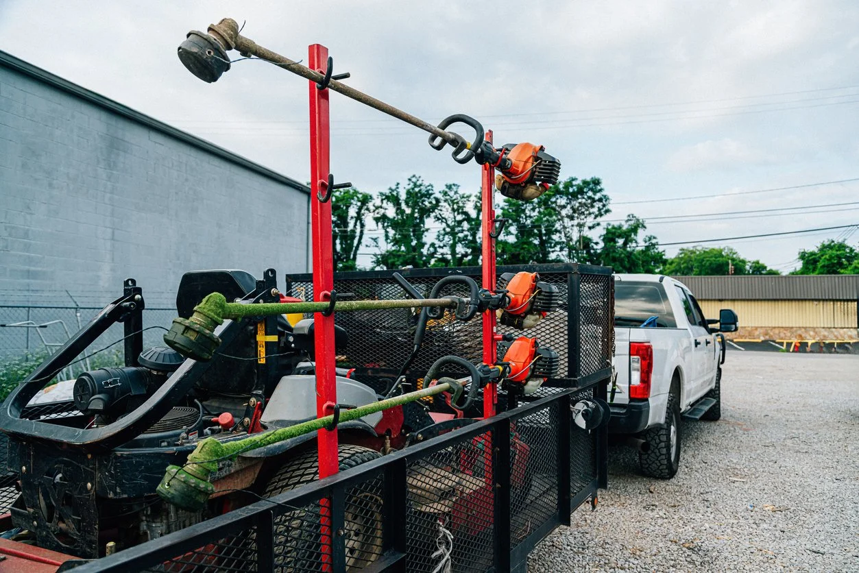 Landscape contractor trailer loaded with zero-turn mower string trimmers and blowers